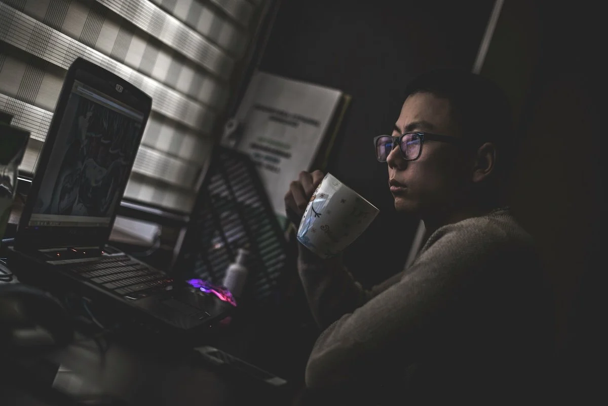 Person sitting at their computer deep in thought