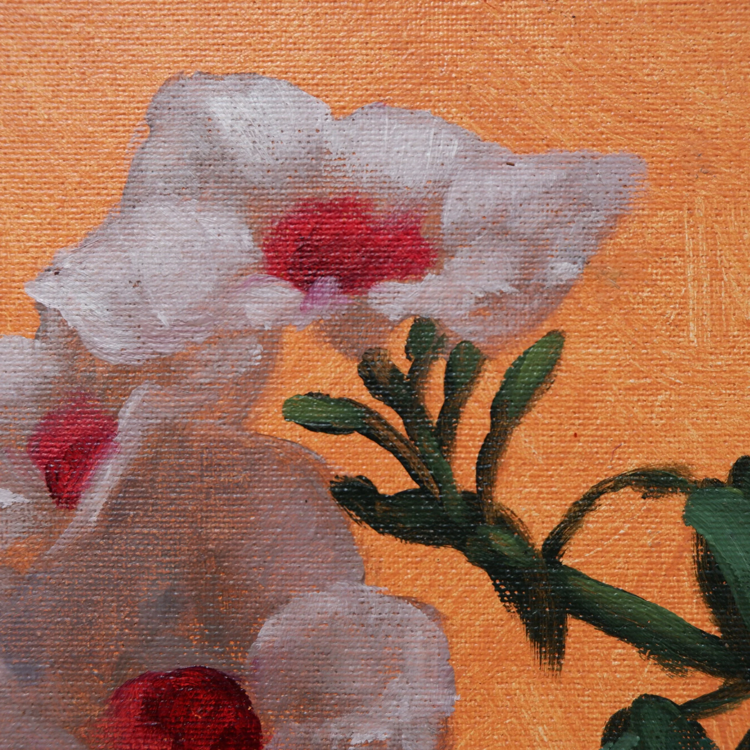 Close-up of a flower painting showing a white flower with pink and red accents on an orange background with green leaves.