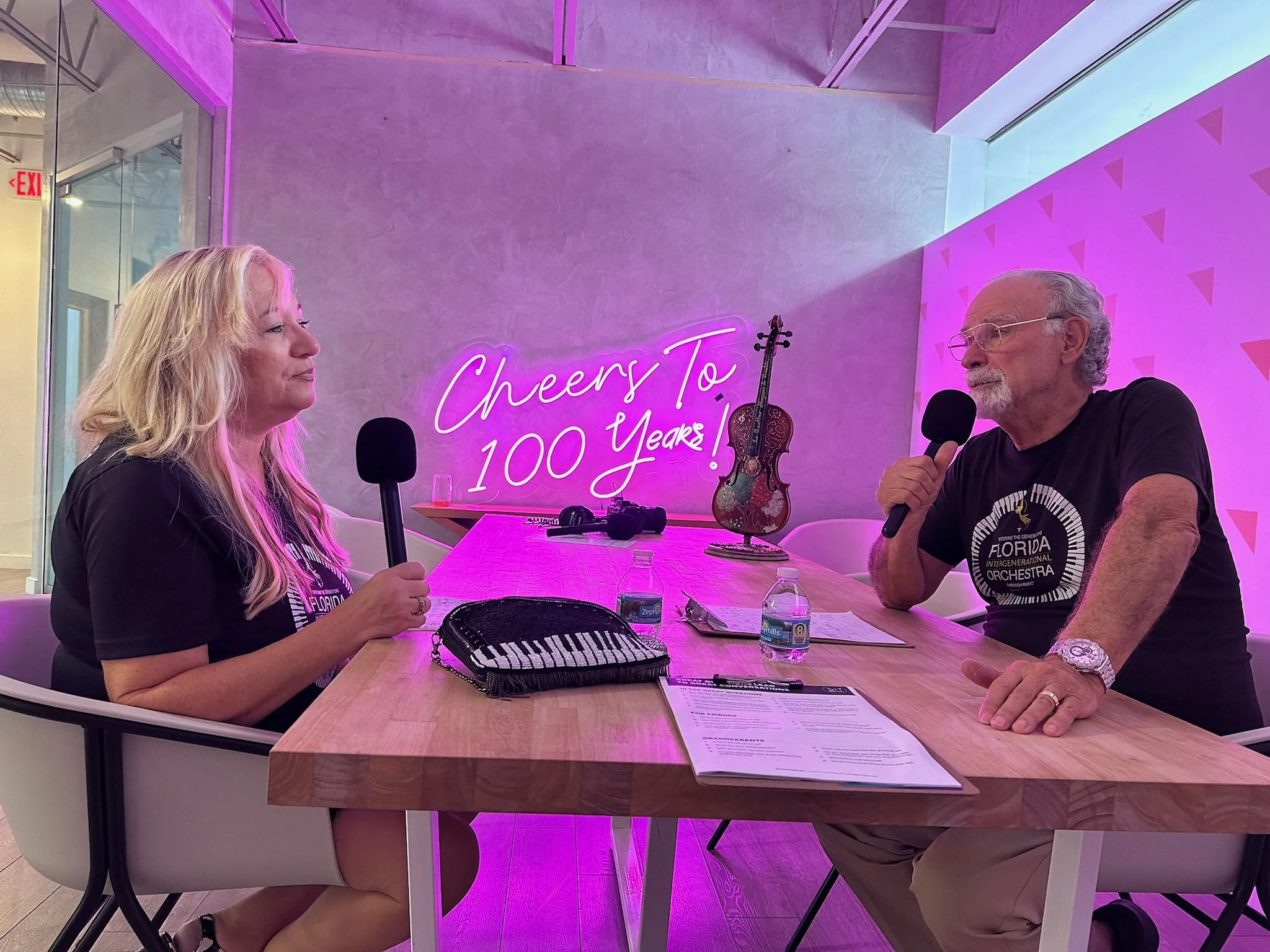 a woman and a man doing a podcast at the flamingo house in east boca raton