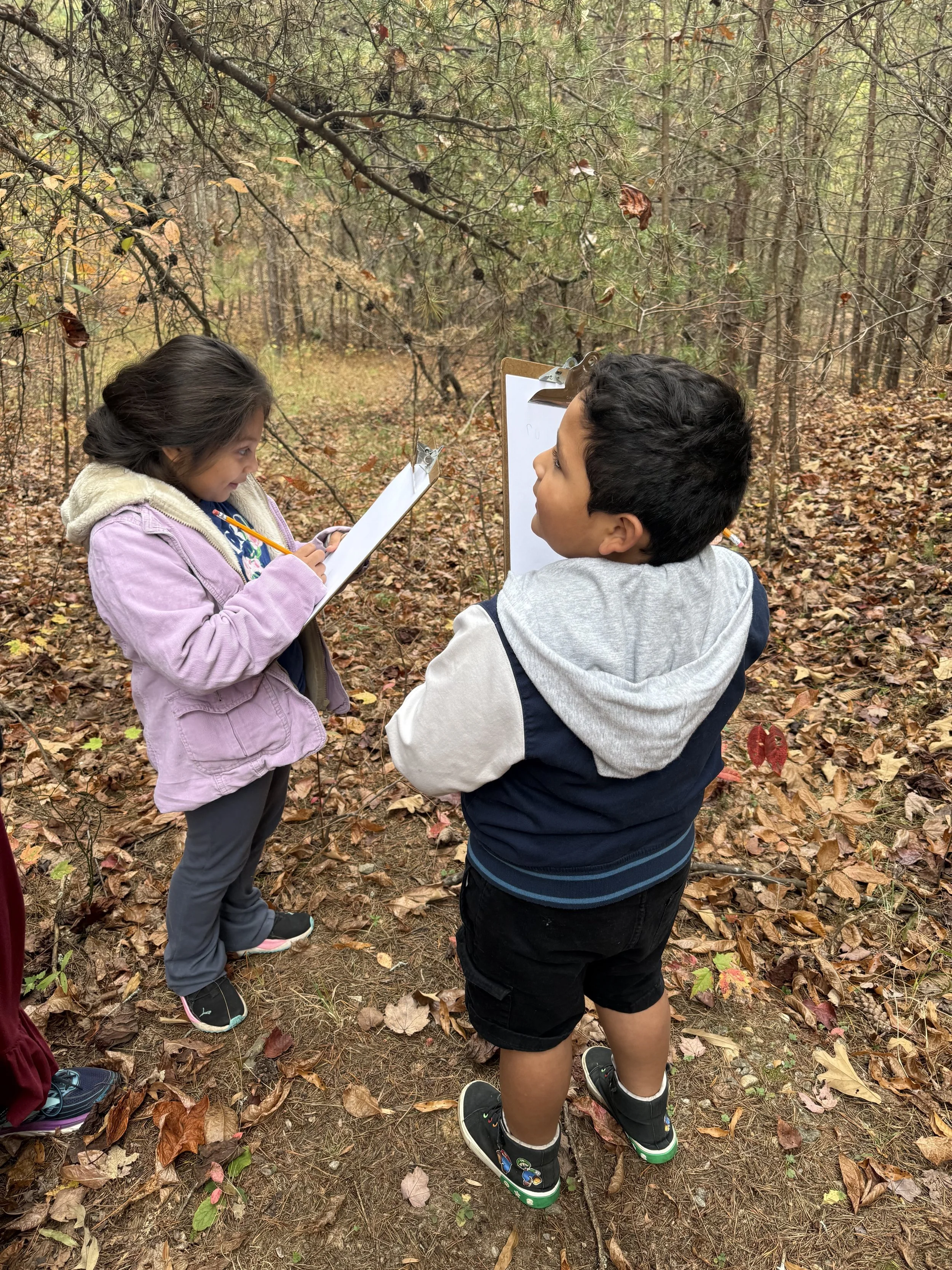 two children nature journaling outdoors