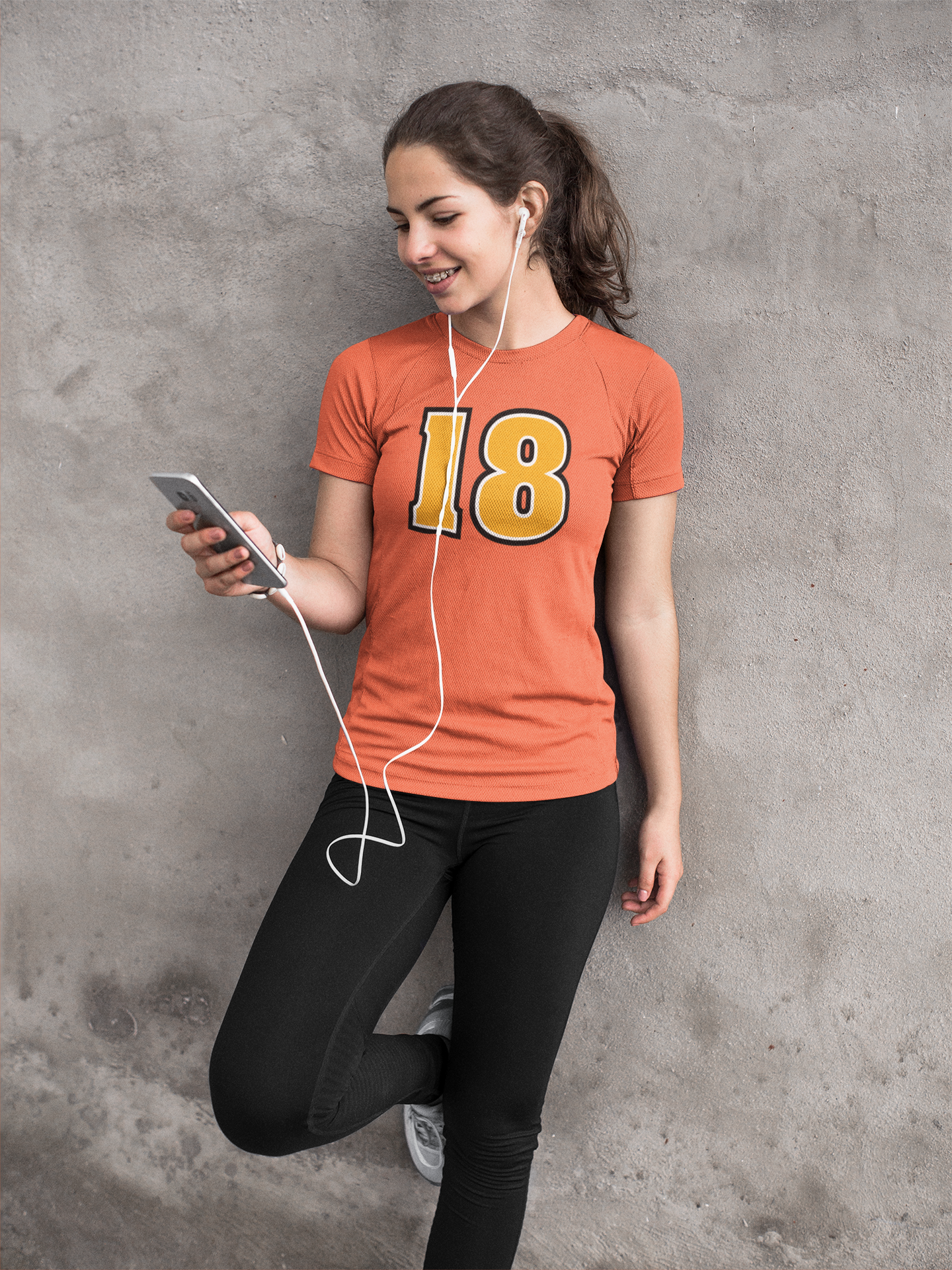 girl-listening-to-music-against-concrete-wall-while-wearing-custom-activewear-mockup-a16863.png