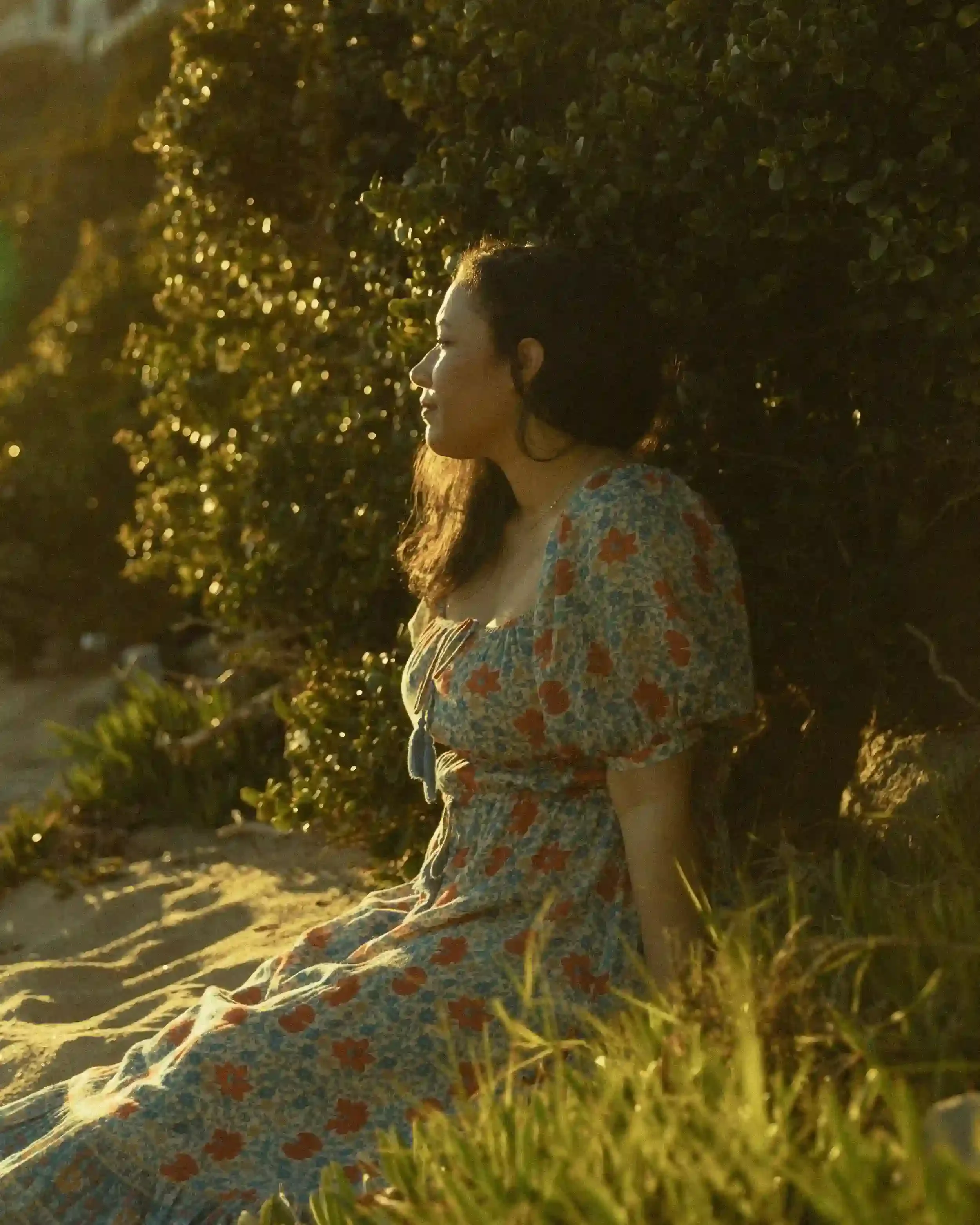 Dr. Adrianna Holness in a floral dress looking at sunset
