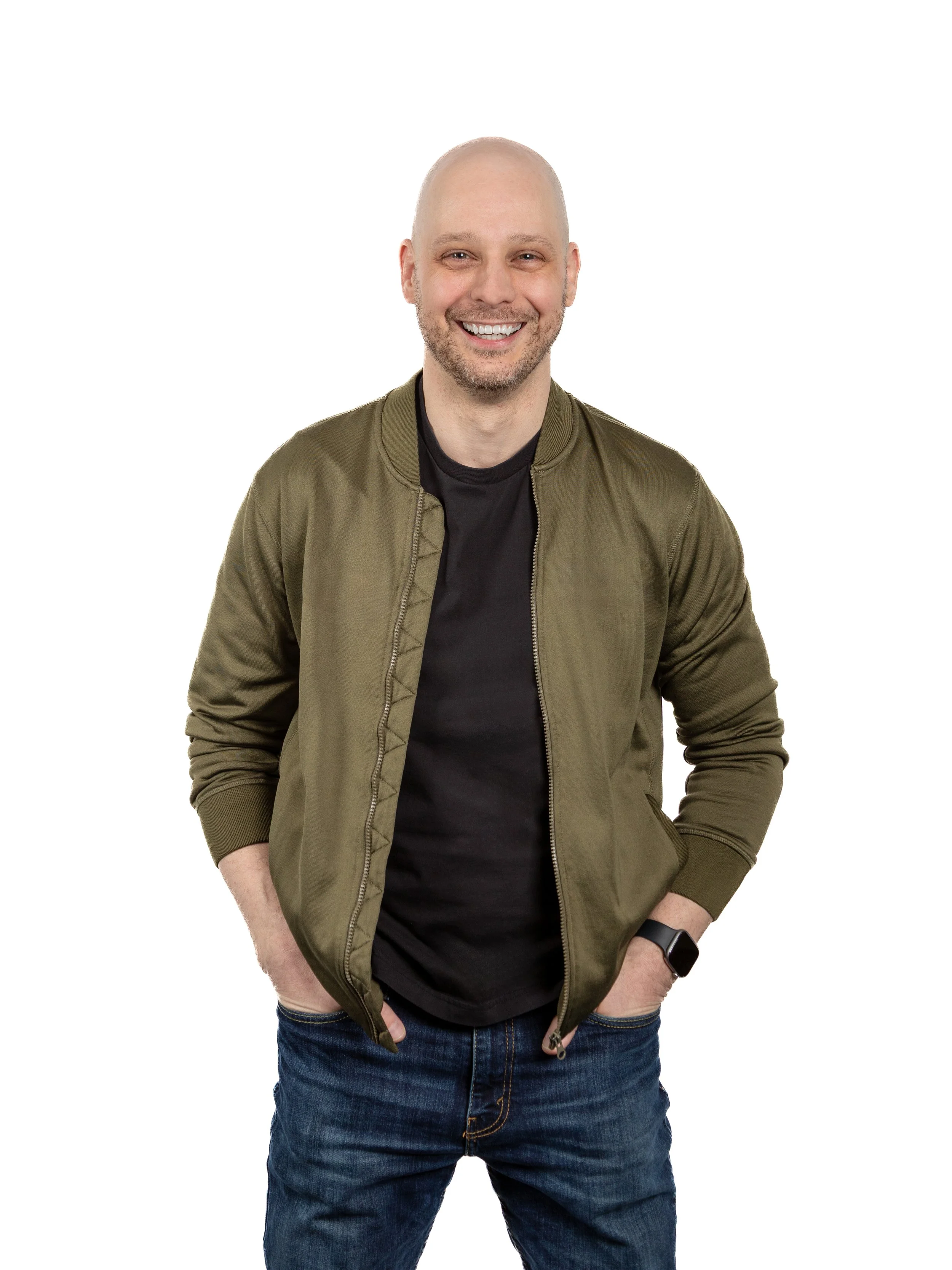 Half body portrait of executive creative director Jerry Hoak sitting in a booth at Galley Kitchen in. Jerry is laughing with a cup of coffee on the table. Behind him on the wall is a chalkboard menu. He is wearing a Converse warmup and jeans.