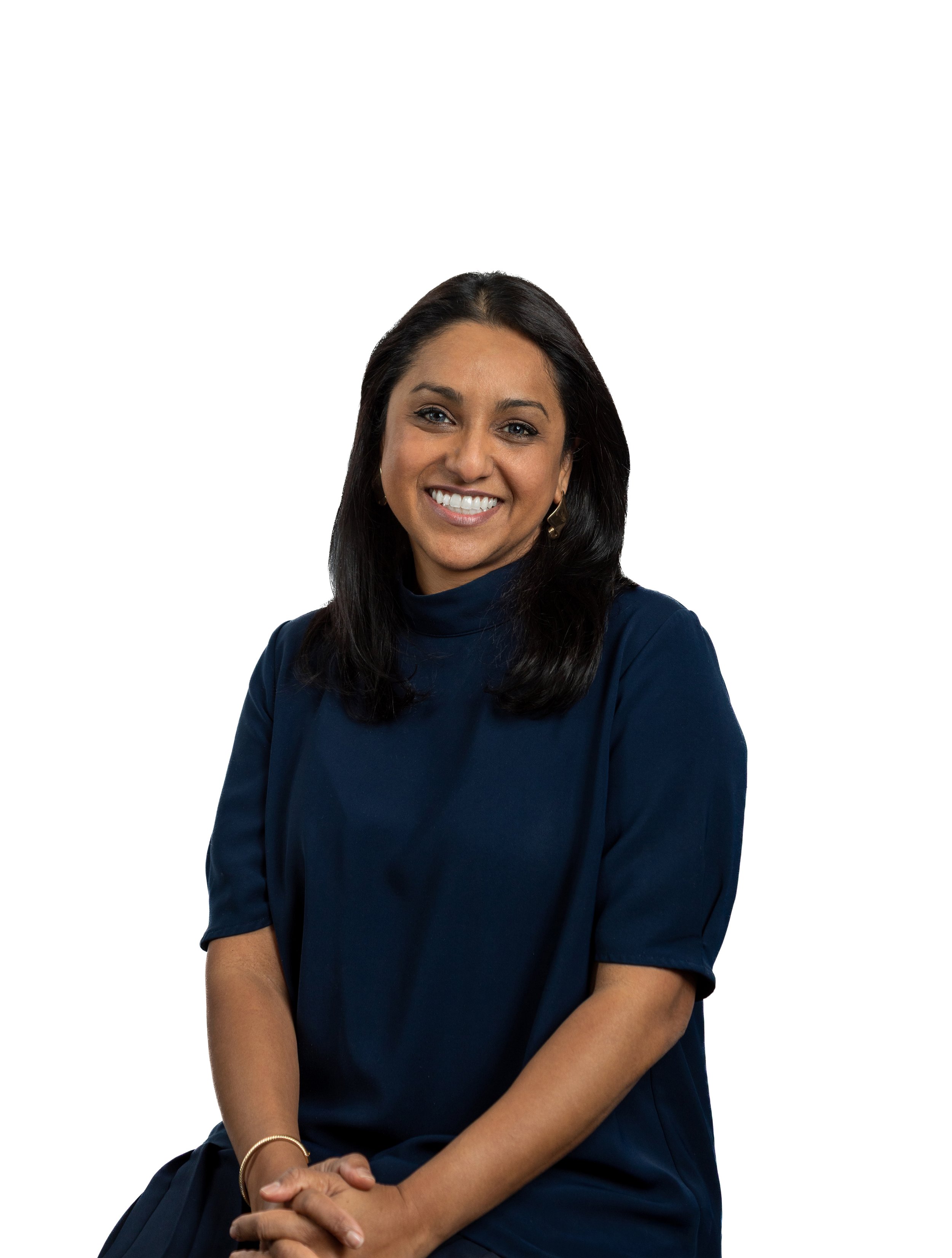 Full body photo of chief revenue officer Tasha Dean in green dress leaning against the railing in the Byrd Theatre in Richmond, Virginia. In the background of the photo, there is a ornate detail of the theater walls and luxurious gold curtains.