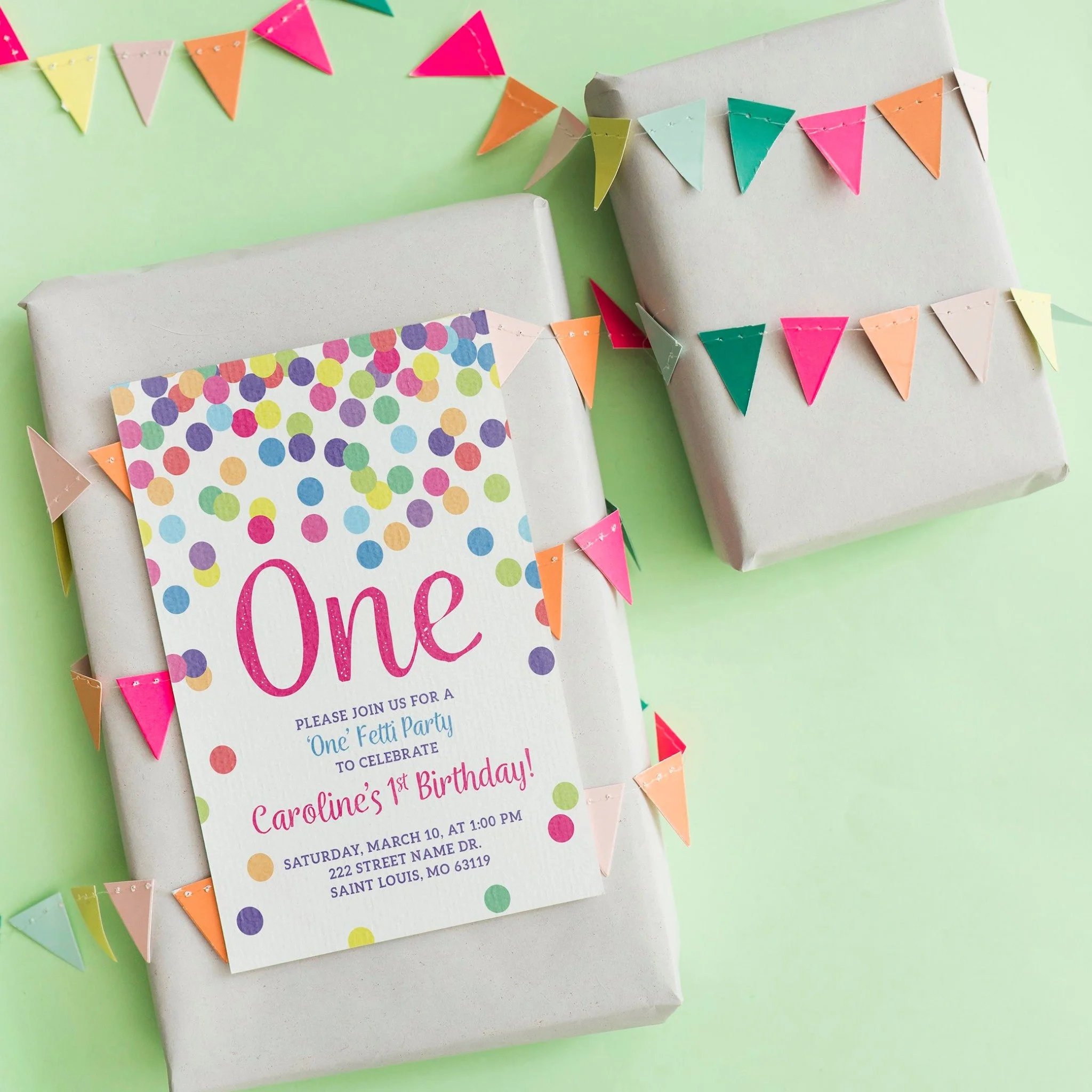 Birthday invitation for a child's first birthday party with colorful polka dots and bunting decorations on a green background.