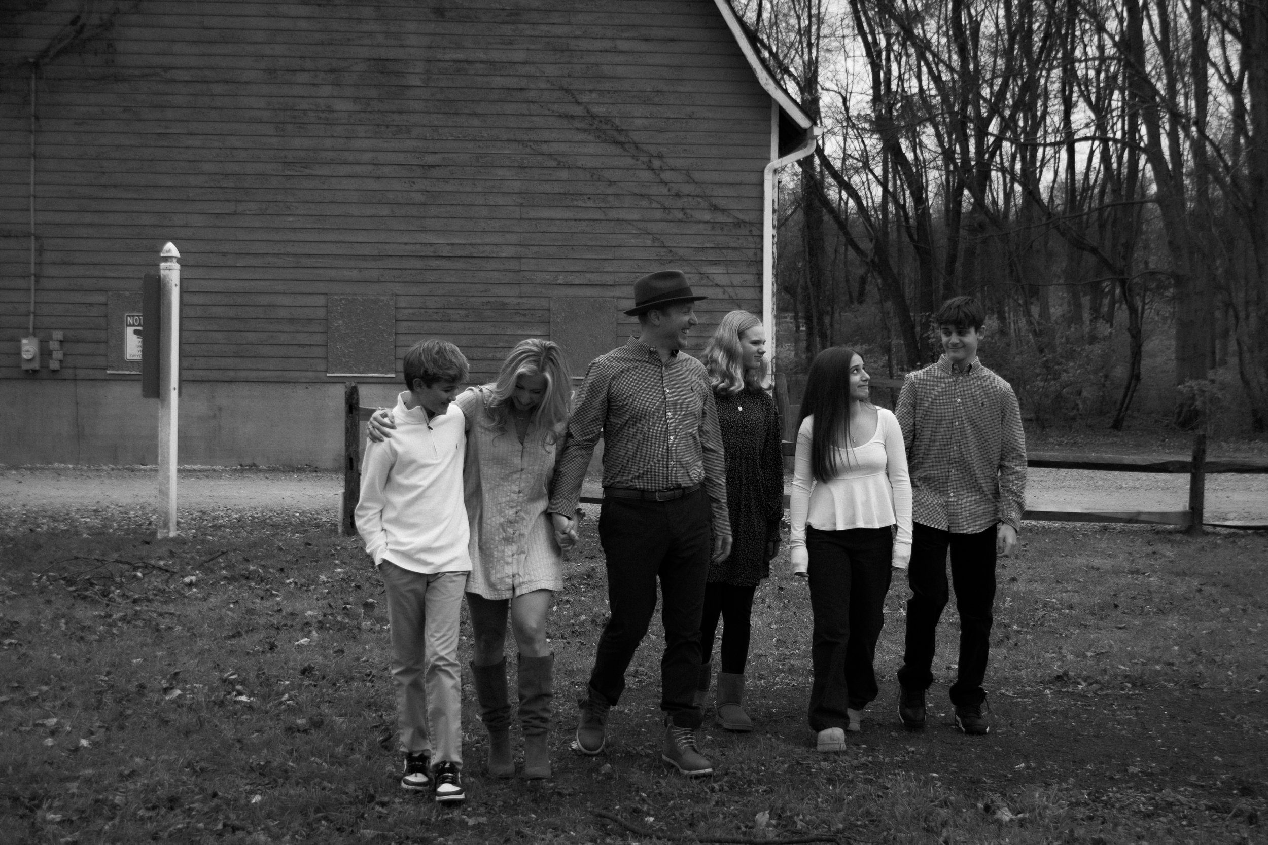 A candid black and white moment of a family walking together, capturing connection, movement, and togetherness.