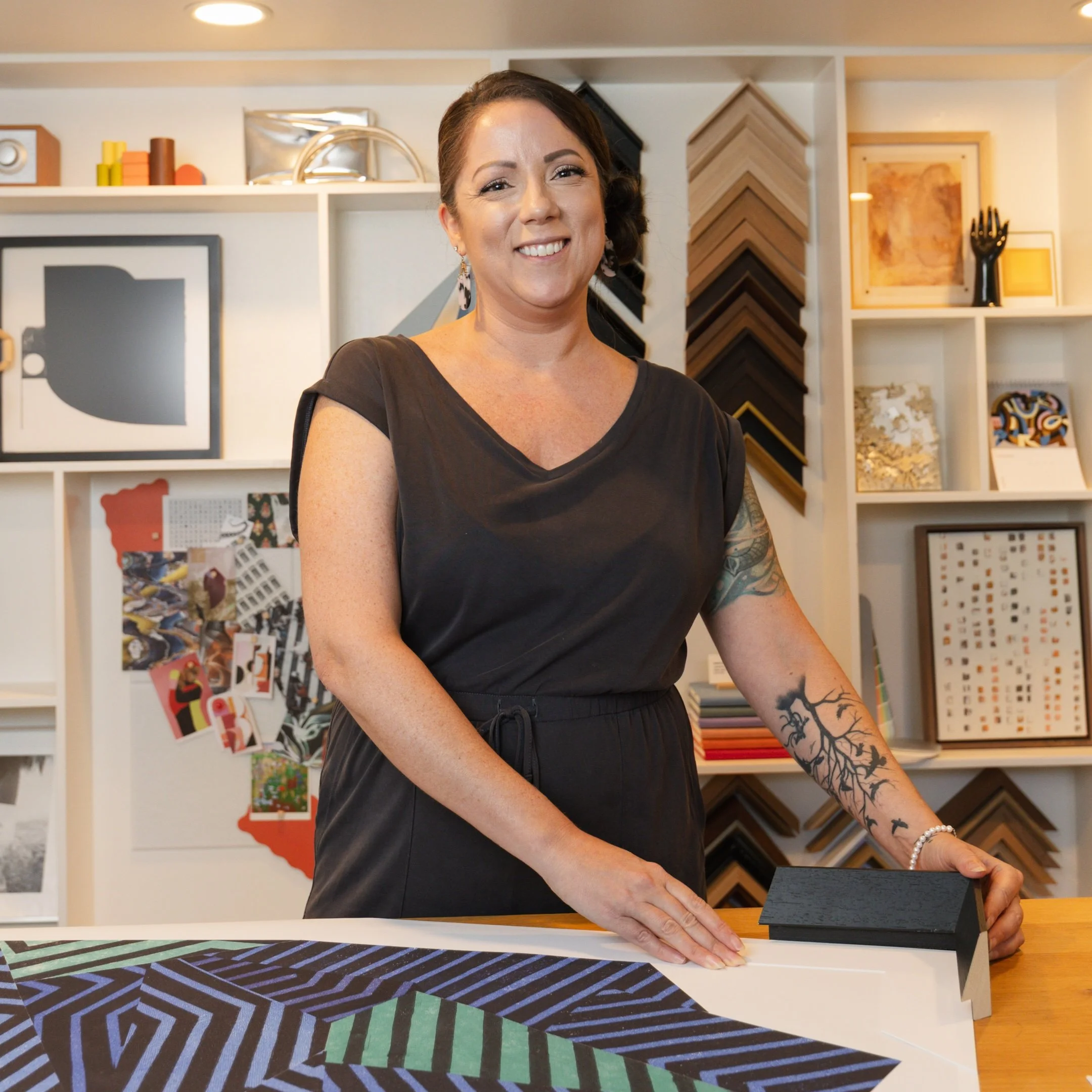 Woman in black shirt working with fabric and color sample swatches in a design studio.