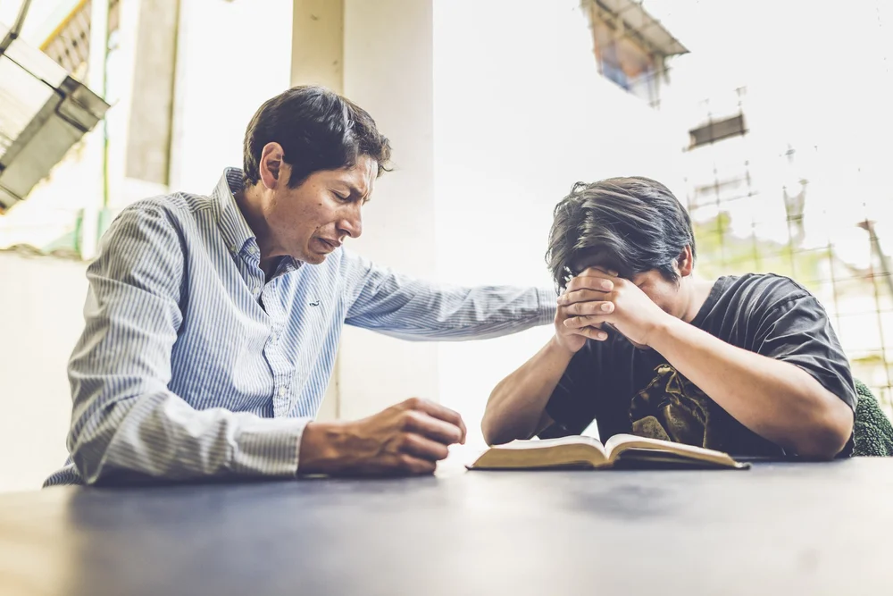 A staff member coaching a younger leader.