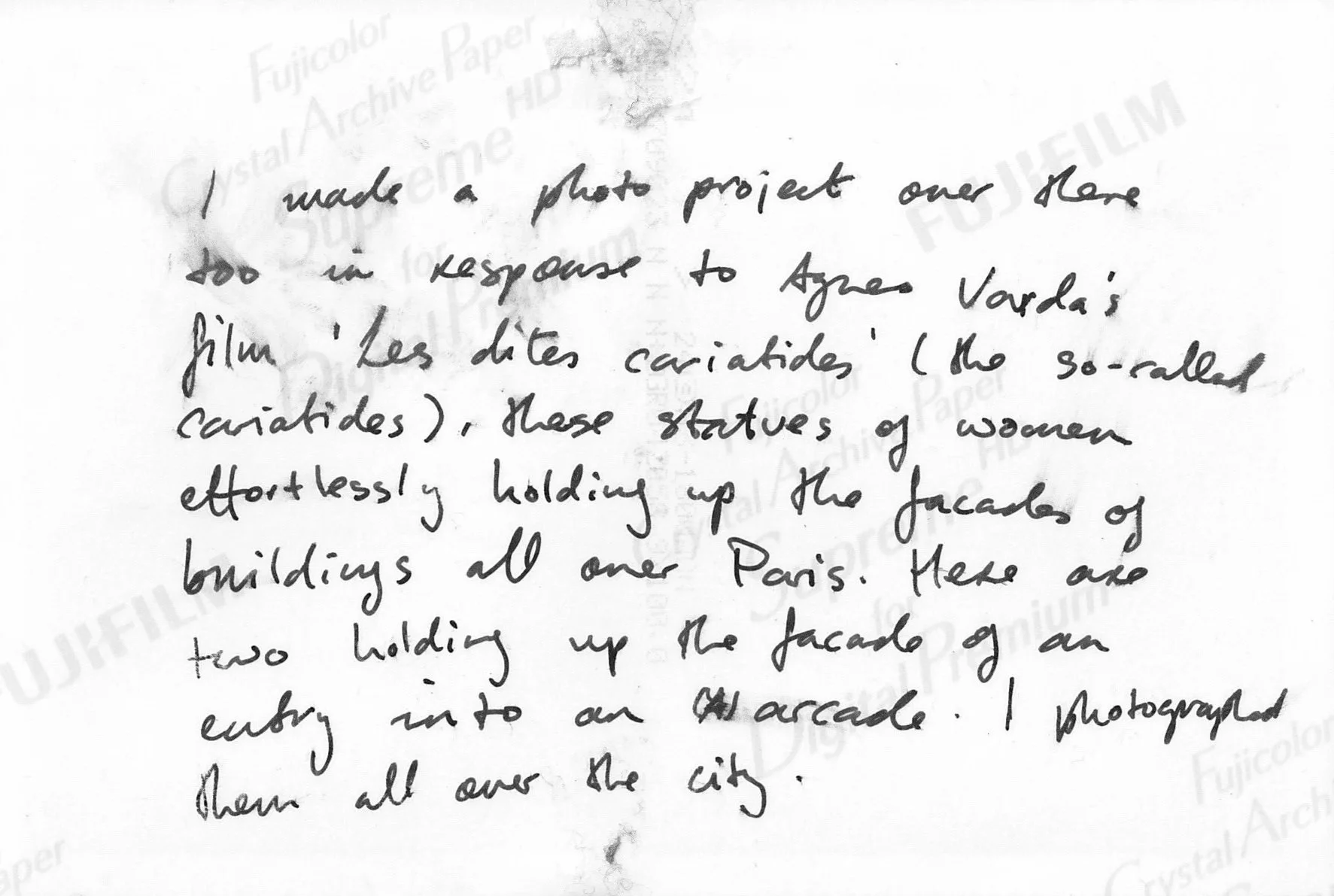 A slightly smudged handwritten note describing a photo project in response to Les dites cariatides (the so-called caryatides) by Agnes Varda that documents statues of women effortlessly holding up the facades of buildings all over Paris.