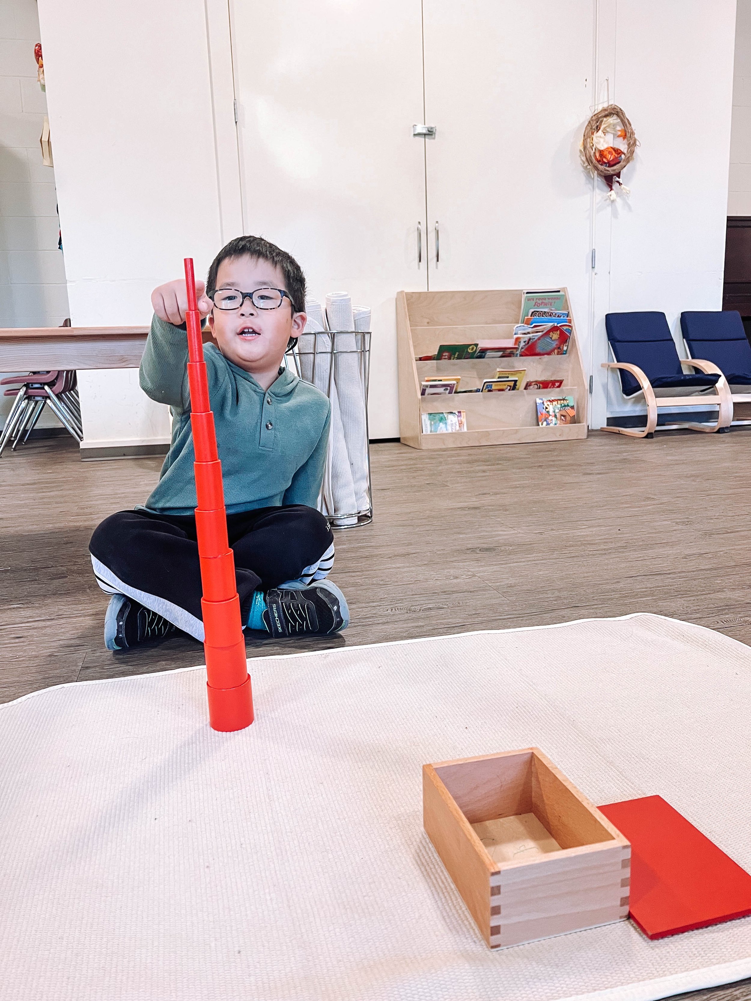 A group of people walking and cycling along a street in an urban area, with tall buildings and a traffic light in view.