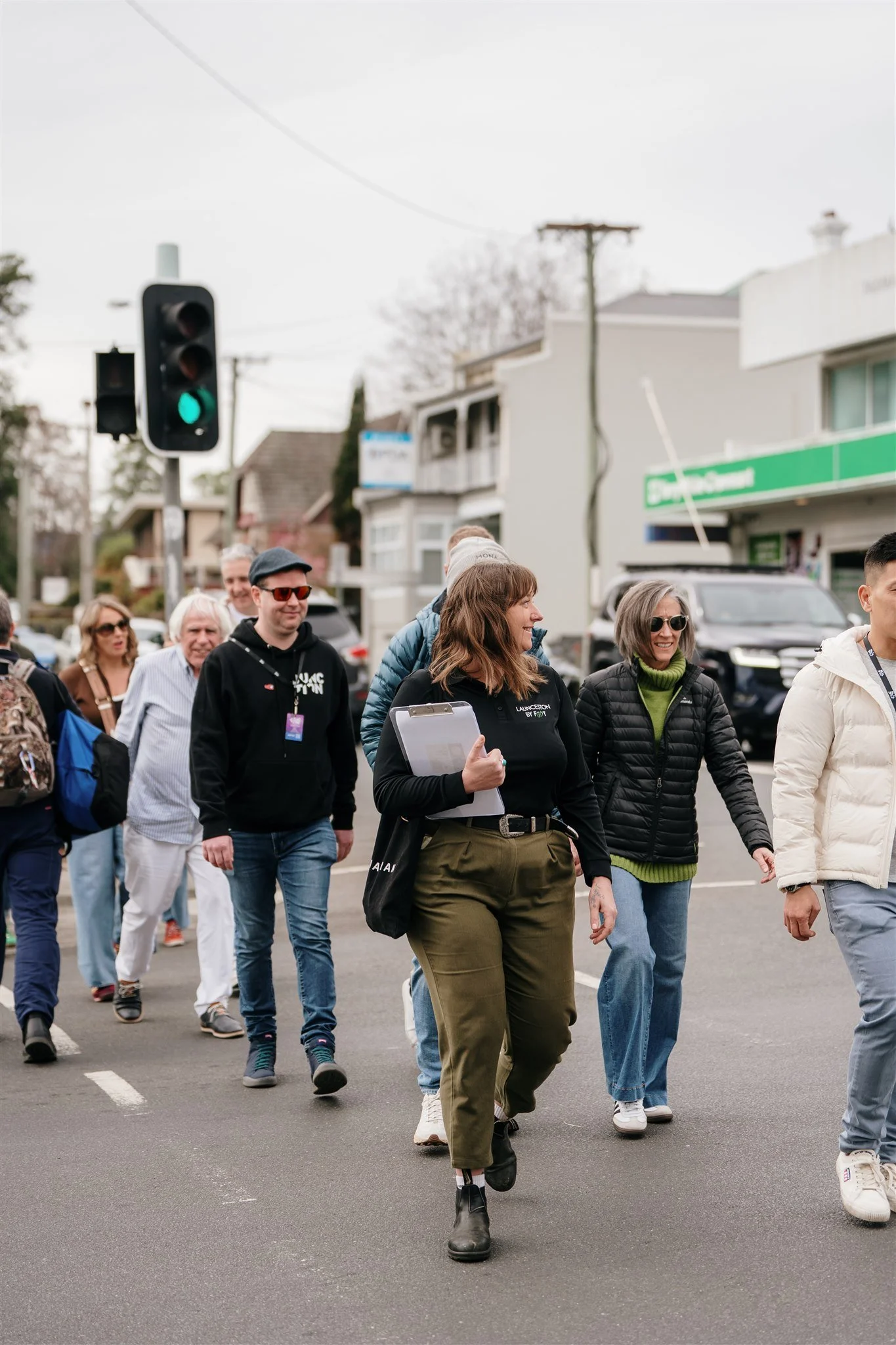 A group of people crossing a street at a crosswalk during daytime.