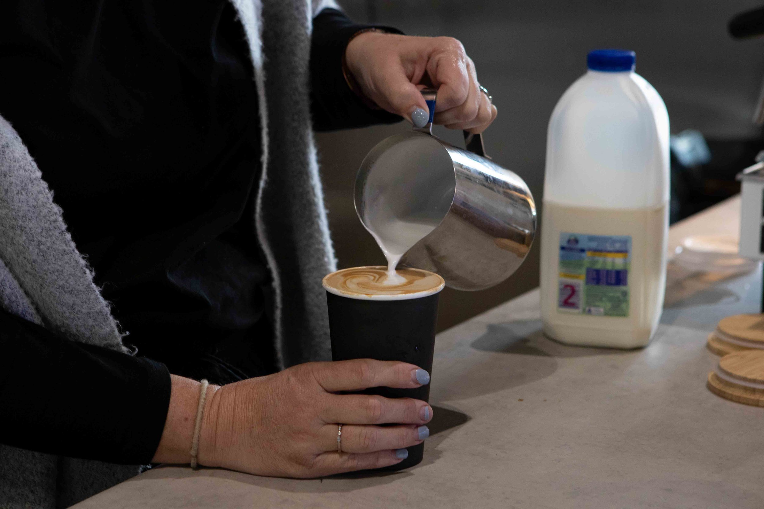 Coffee being poured into a takeaway cup.