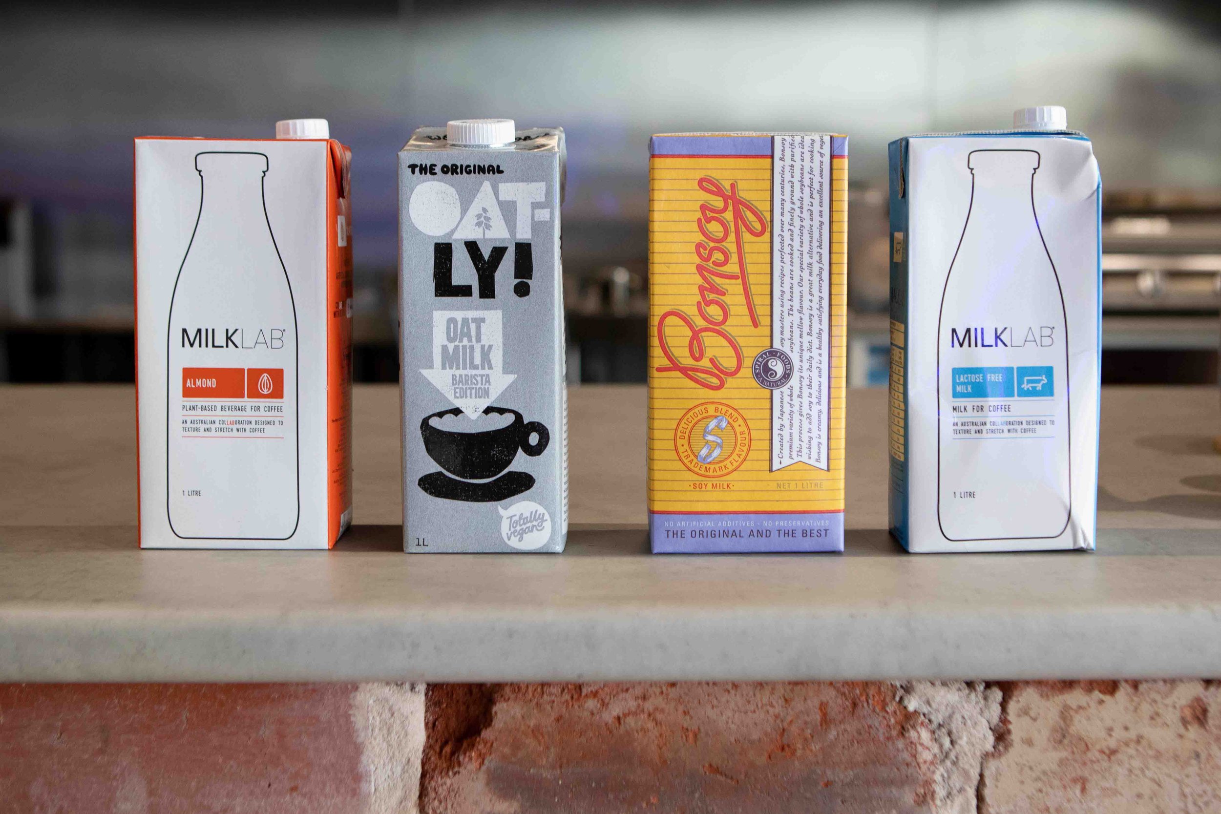 Alternative milk varieties sitting on the counter including milk lab almond milk, oatly oat milk, bonsoy soy and milk lab lactose free