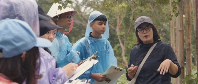Students conducting field research or taking notes during an educational trip.
