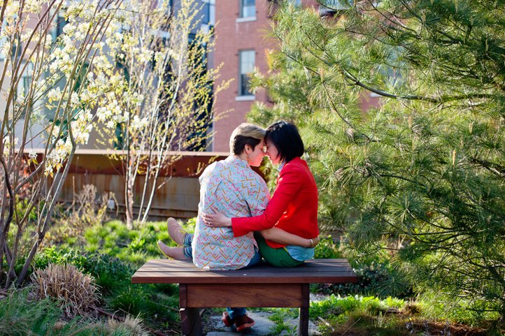 Alice &amp; Catie embrace while sitting on a bench at a park in Brooklyn, NY