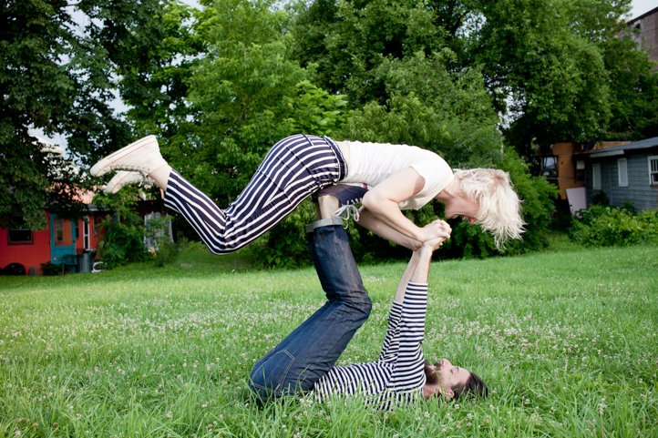 Randy lifts Kelsey Taylor up in the airplane pose with his feet in the grass in the yard of their home in Hudson, NY