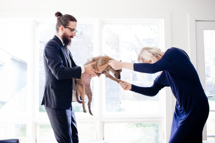 Randy & Kelsey Taylor dance while holding their small dog in their home in Hudson, NY