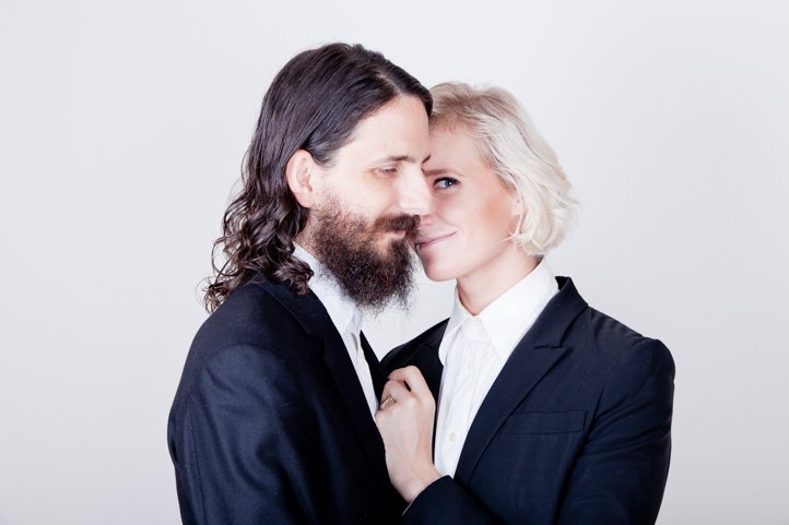 Randy &amp; Kelsey Taylor embrace while wearing suits in their home in Hudson, NY