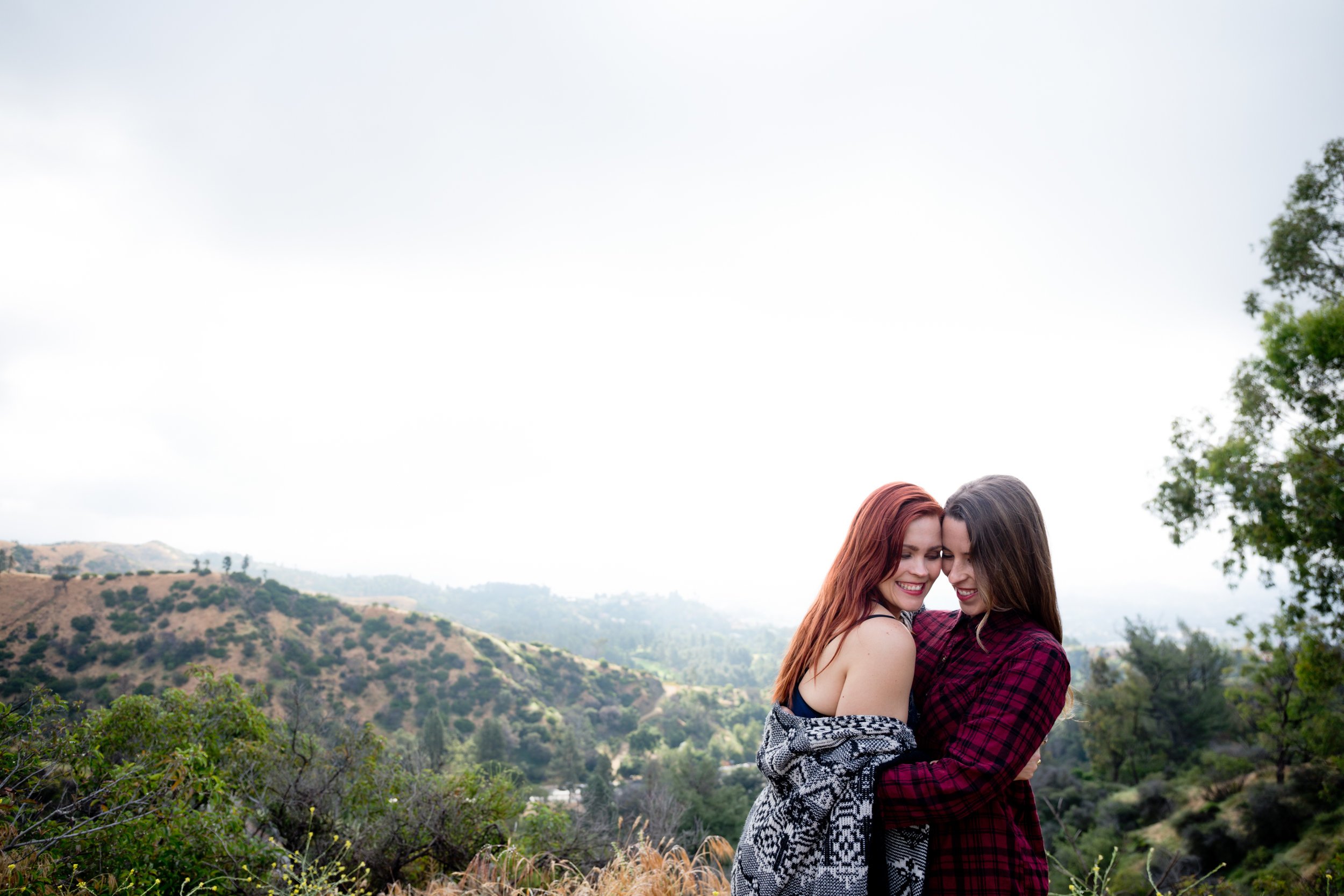 Courtney &amp; Tierney embracing with the hills of Los Angeles in the background