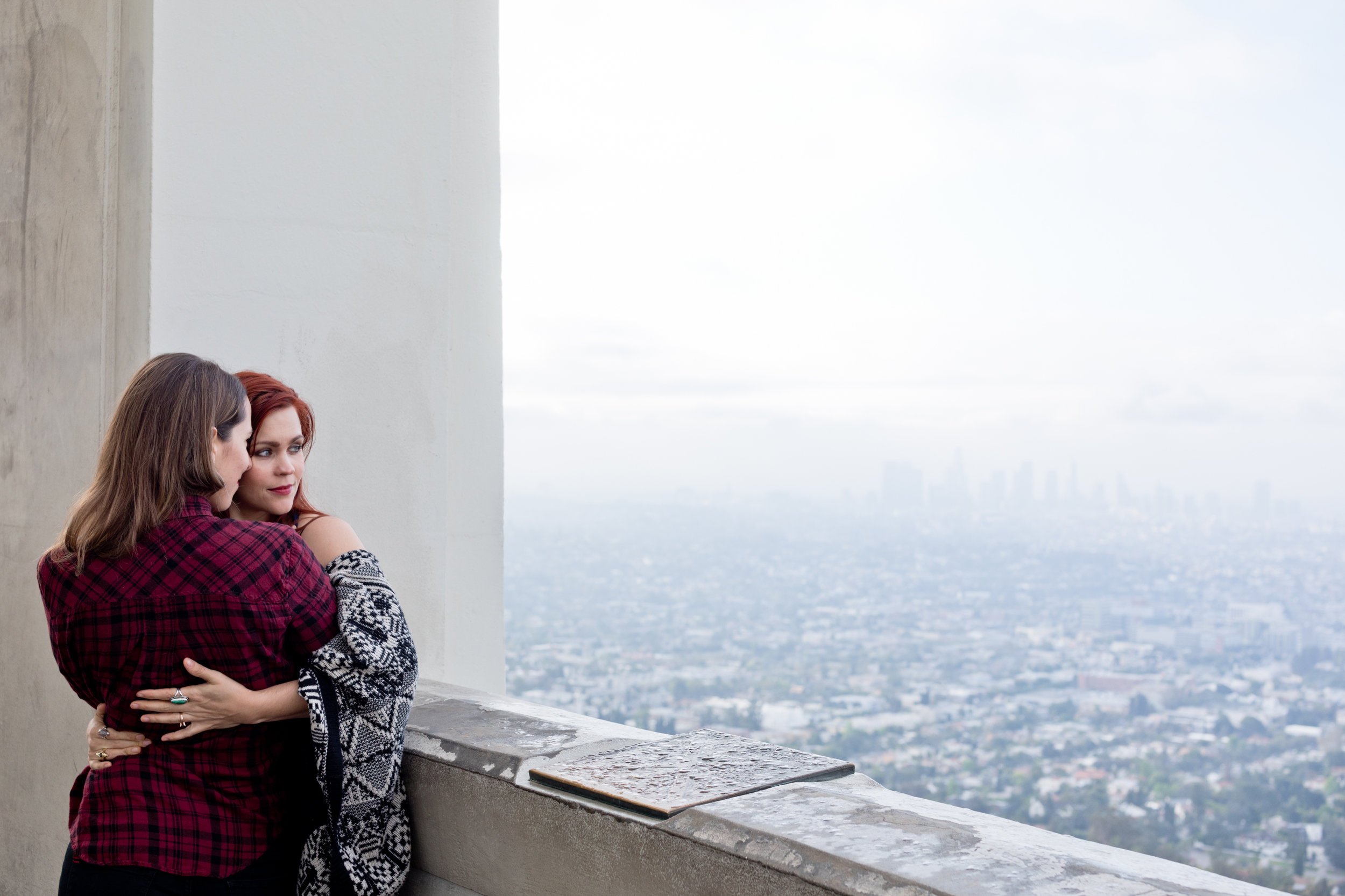 Courtney &amp; Tierney embracing at the griffith observatory with LA in the background
