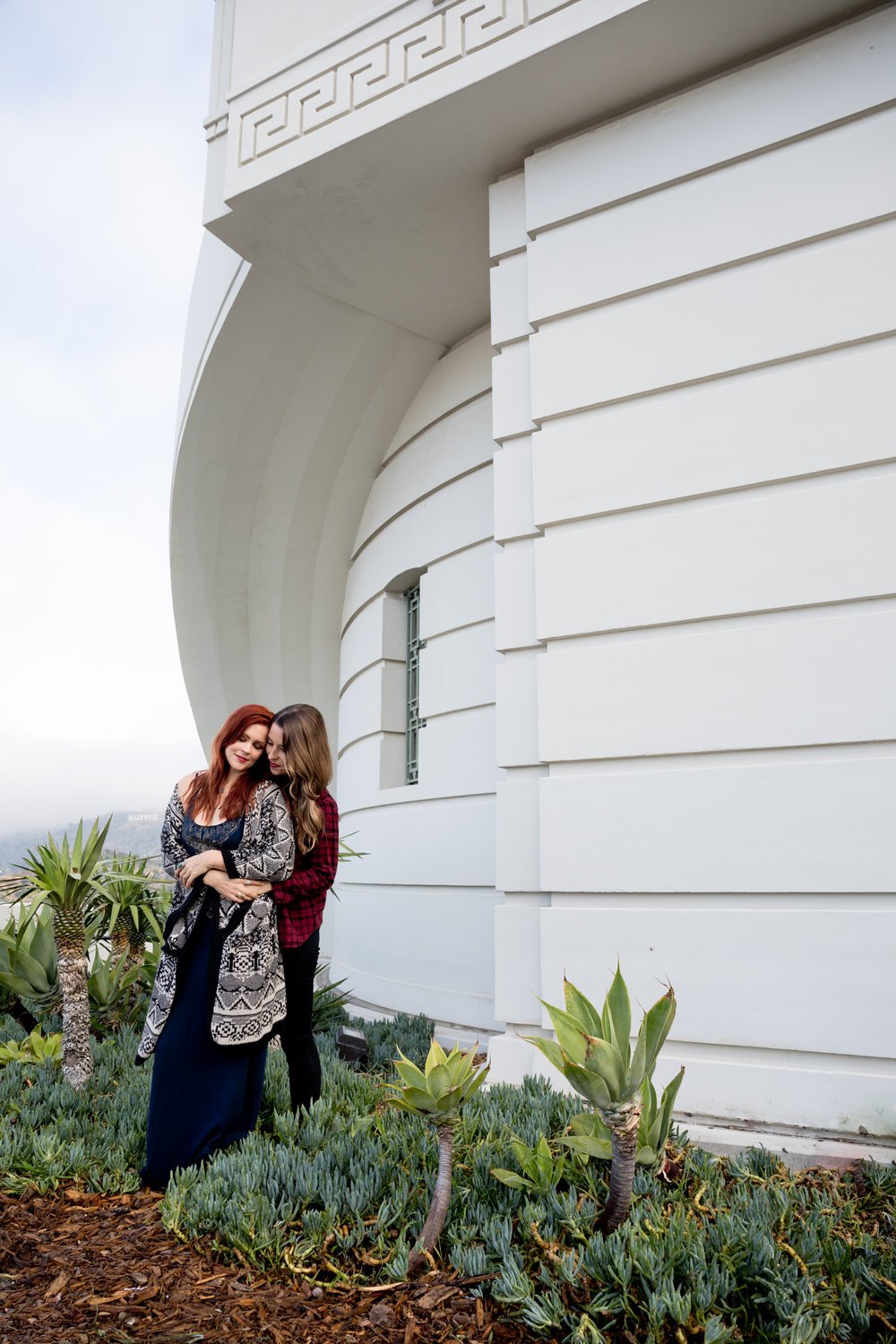 Courtney &amp; Tierney embracing at the griffith observatory in the background