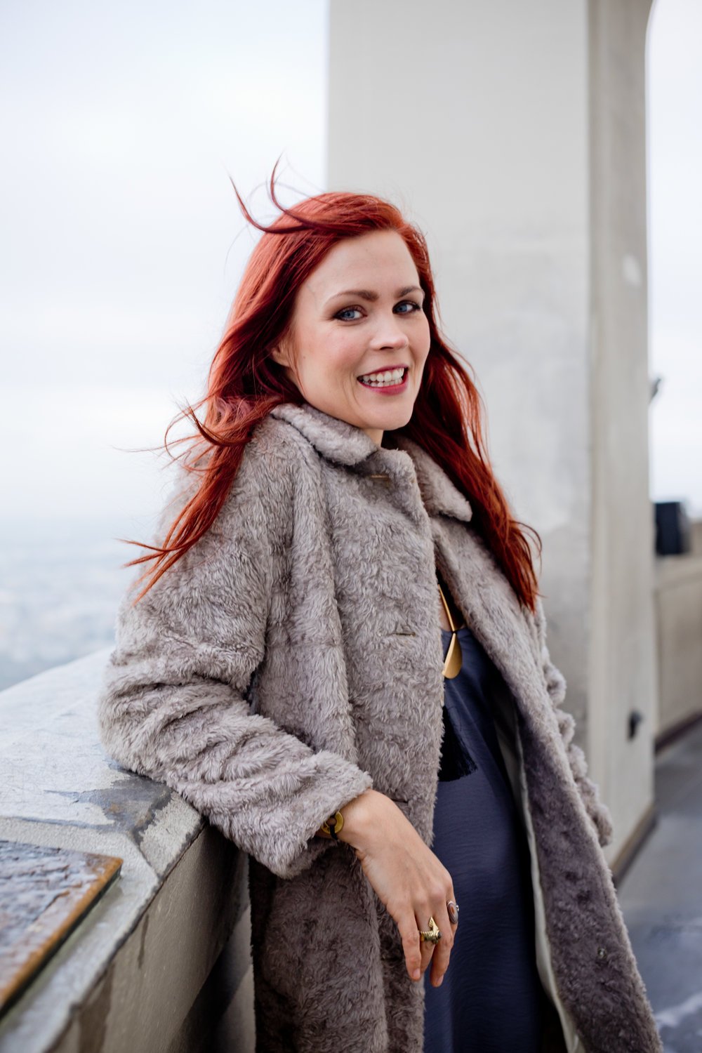Headshot of woman with red hair, smiling, at the Griffith Observatory in LA
