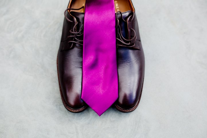 One groom's purple tie laying atop his shoes