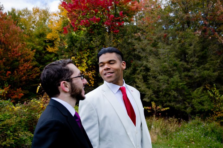 Arthur &amp; Scott look at each other lovingly with red, orange, and yellow trees behind them in the Catskills