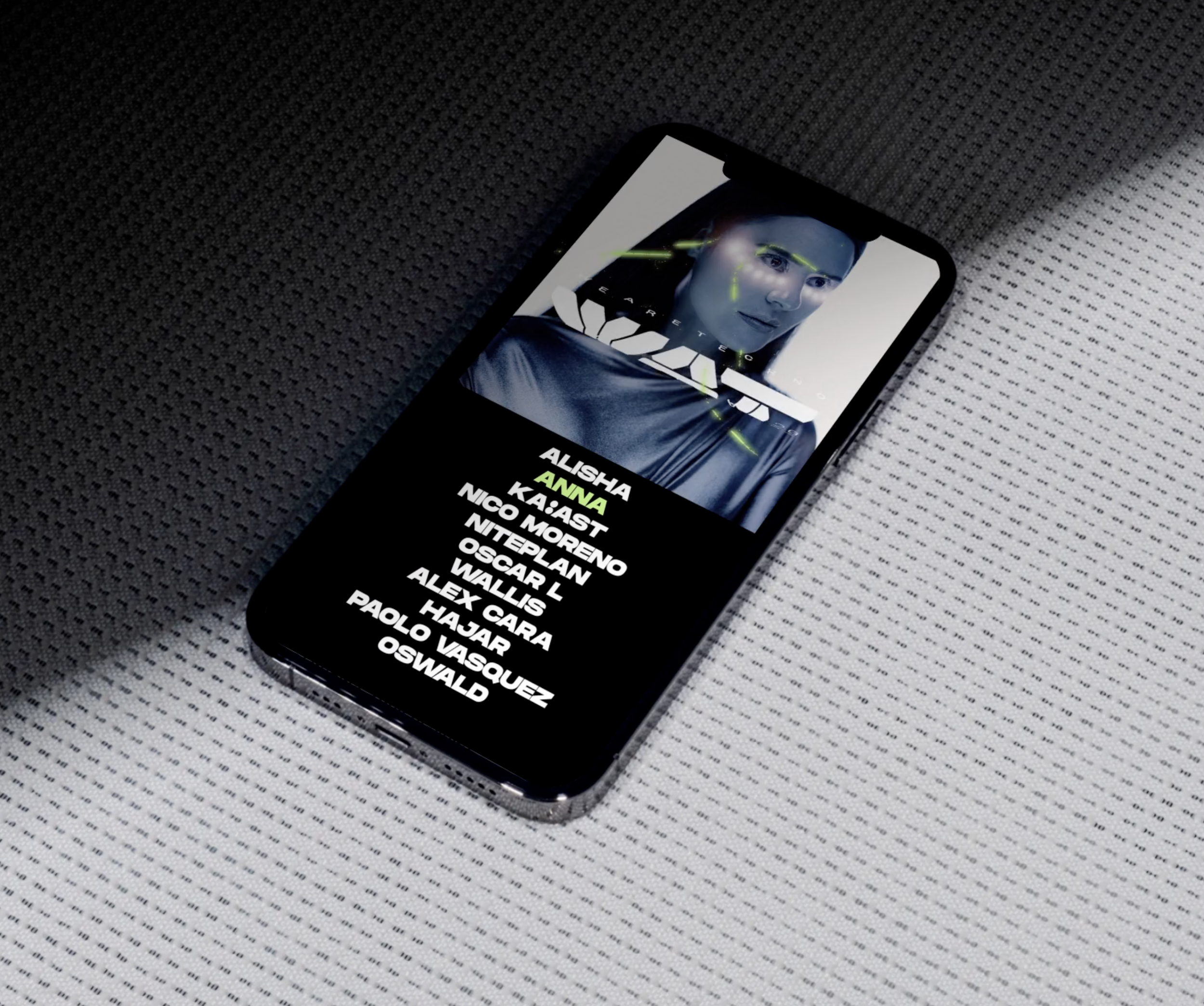 Un téléphone portable affichant une image d'une femme avec des éléments graphiques verts et une liste de noms en français. Le téléphone repose sur un tissu noir avec un motif à petits points.