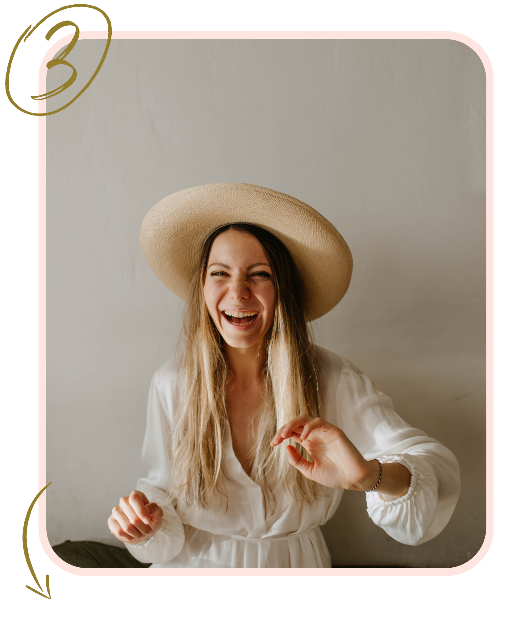 A woman wearing a white dress and beige sun hat. She has a huge smile on her face and seems very happy.