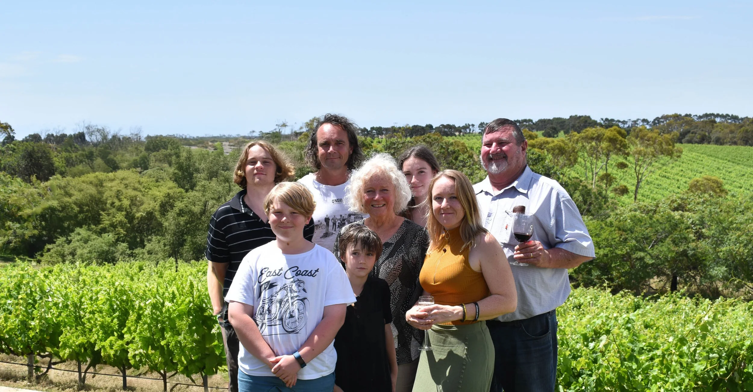 The Hooper family standing together among vineyard rows at Cape Jaffa Wines; three generations shaping this Limestone Coast winery near Robe.