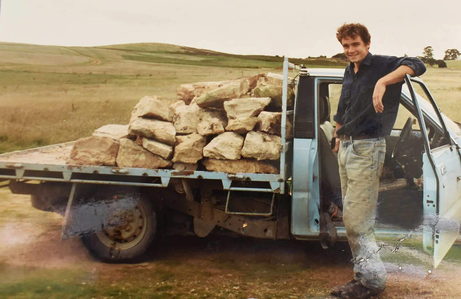Young Derek Hooper standing beside a ute loaded with limestone rock; laying foundations for Cape Jaffa Wines on South Australia's Limestone Coast.