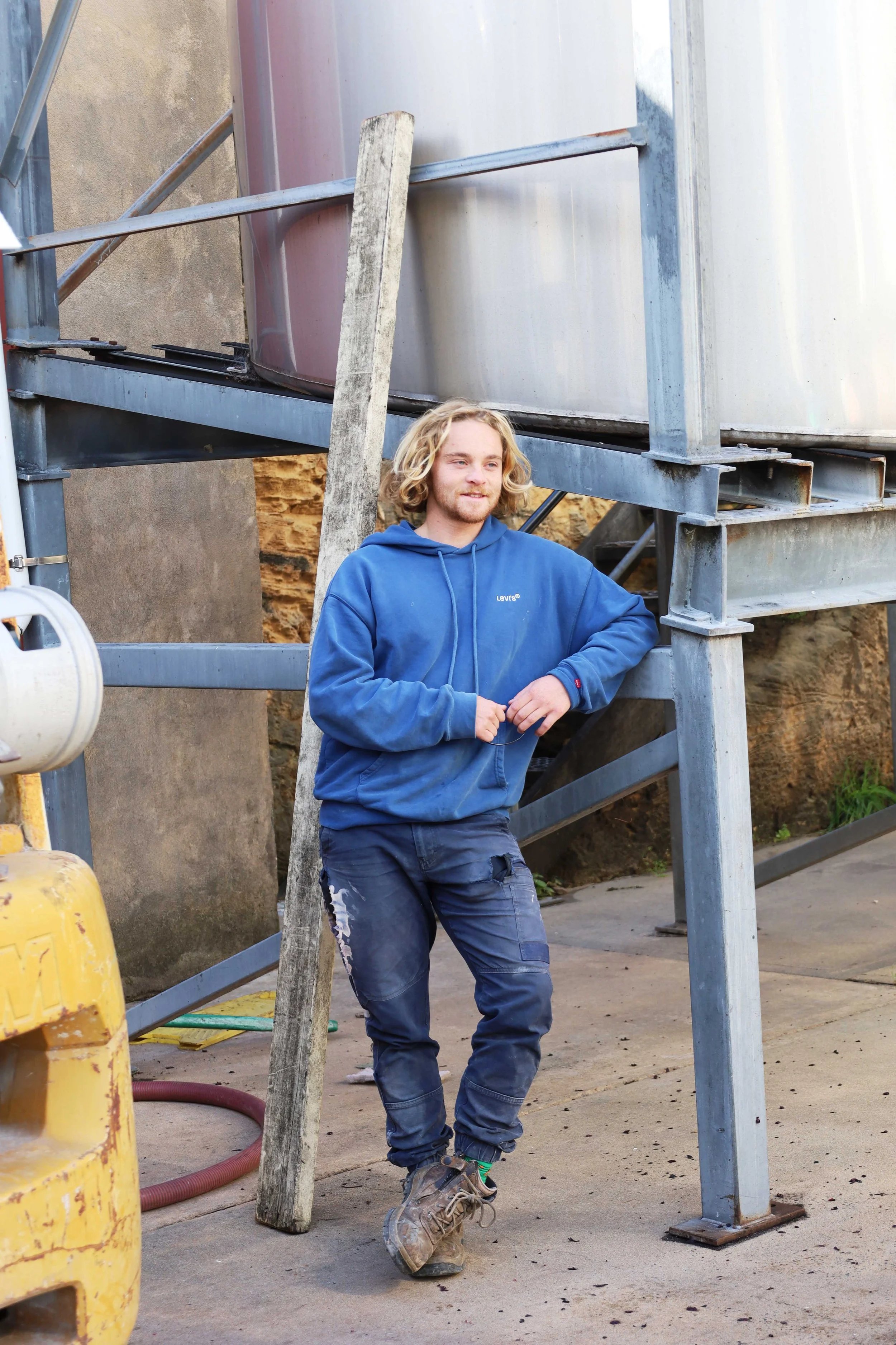 Harry Hooper standing at Cape Jaffa Wines in vintage workwear; part of the Hooper family's next generation of winemakers on the Limestone Coast.