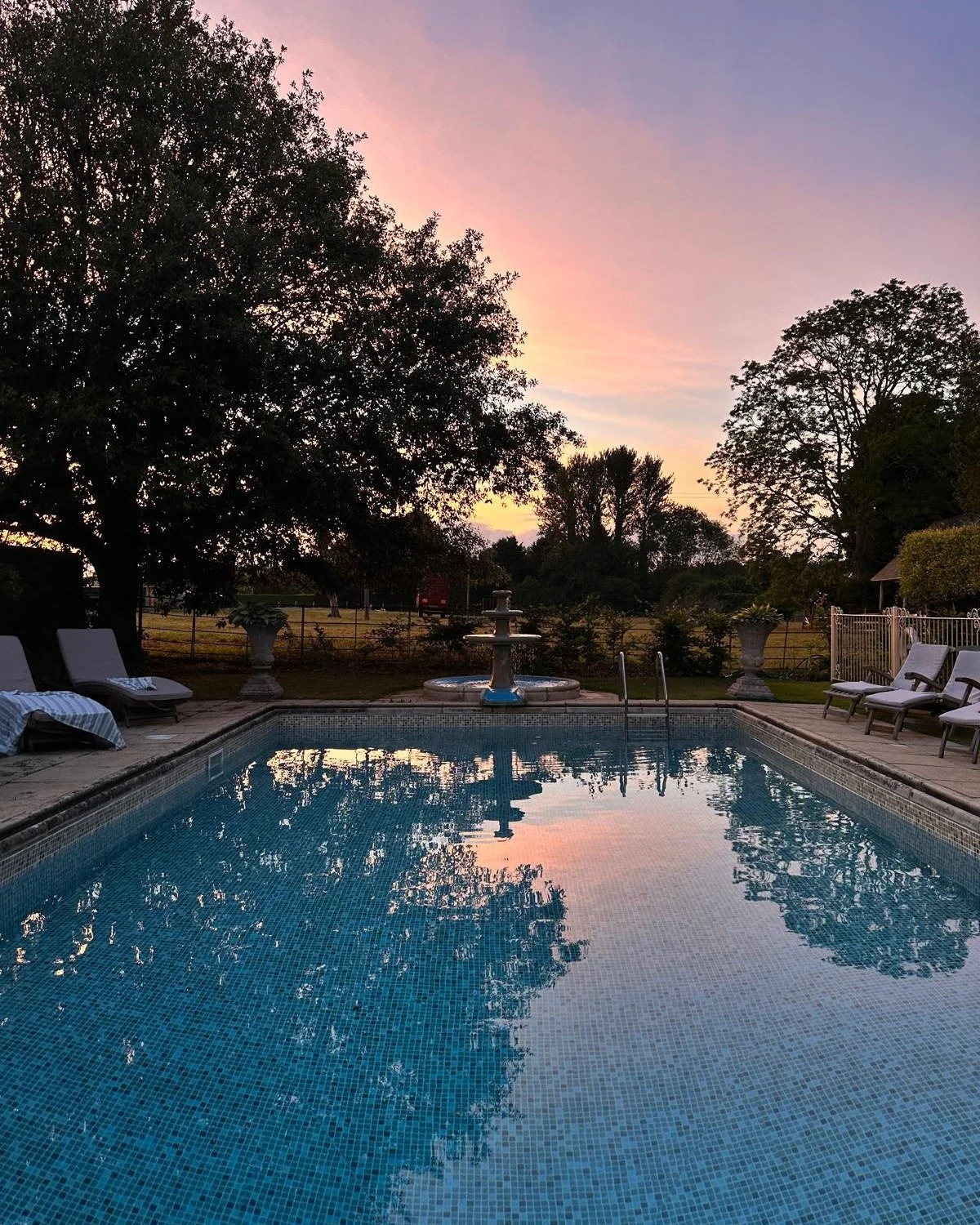 When dusk falls and the sky turns pink over the fields beyond the pool, the Cotswolds stone glows warm. Some moments are worth staying in for. 
.
.
.
.
#CotswoldsLuxury #LuxuryHomeRental #CotswoldsGetaway #HolidayLet #cotswoldssunset