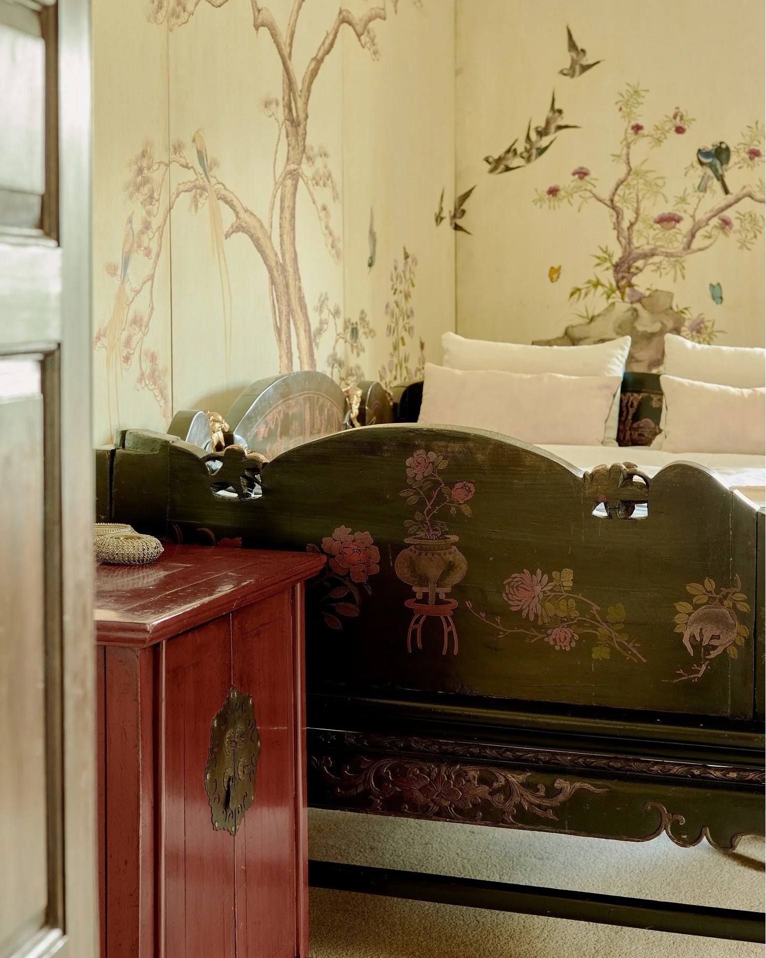 Details from the Master bedroom. Brimming with stories and history, an ornately carved antique Chinese opium bed serves as the centrepiece. Hand-painted murals adorn the walls; Jim Thompson silks dress the curtains and upholstery. The en-suite is lux