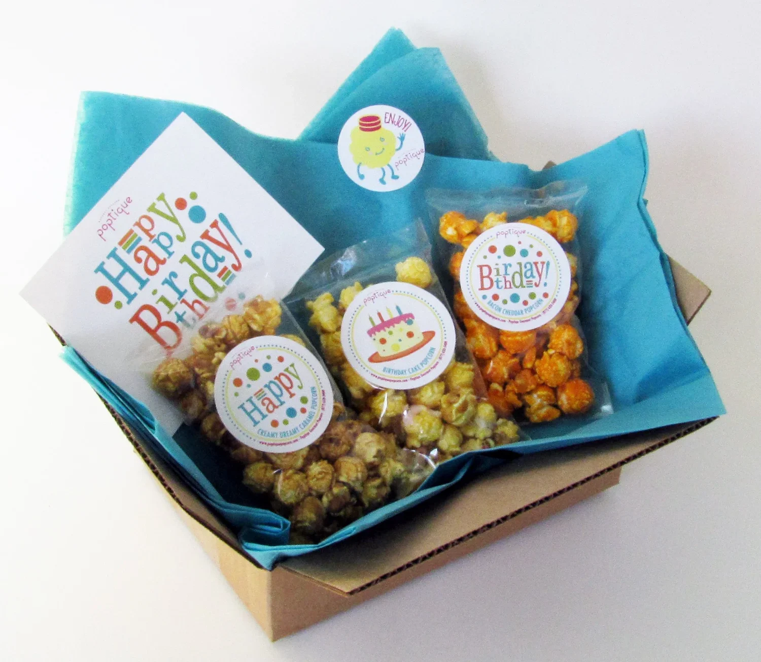 A birthday gift box with colorful popcorn bags and birthday-themed stickers, including a cupcake, cake, and message saying 'Happy Birthday!'
