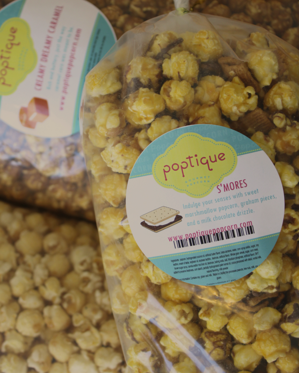 Close-up of a bag of Gourmet S'mores popcorn by Poptique, with popcorn flavored with marshmallow, graham cracker pieces, and milk chocolate drizzle in a clear plastic bag.