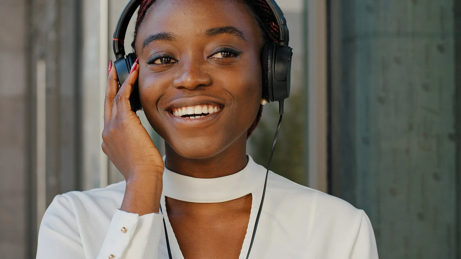 Young African American woman listening to music with headphones on representing someone using music during expressive therapy in California.