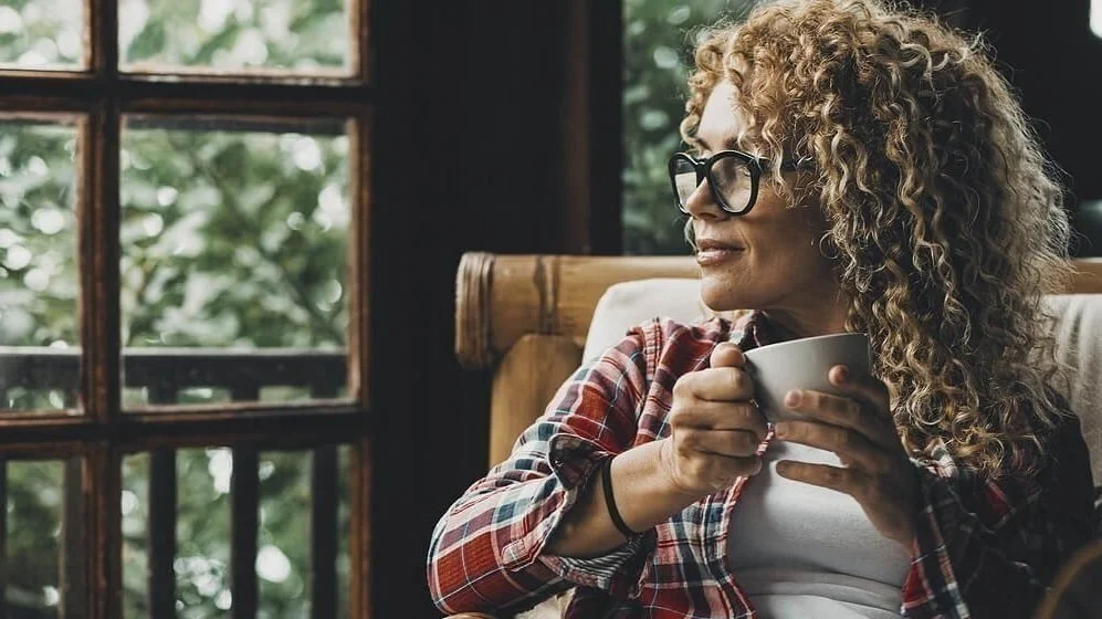 This is an image of a midlife woman drinking coffee while thinking about her life.Jessika Fruchter LMFT specializes in the support of women navigating perimenopause and midlife women in California.