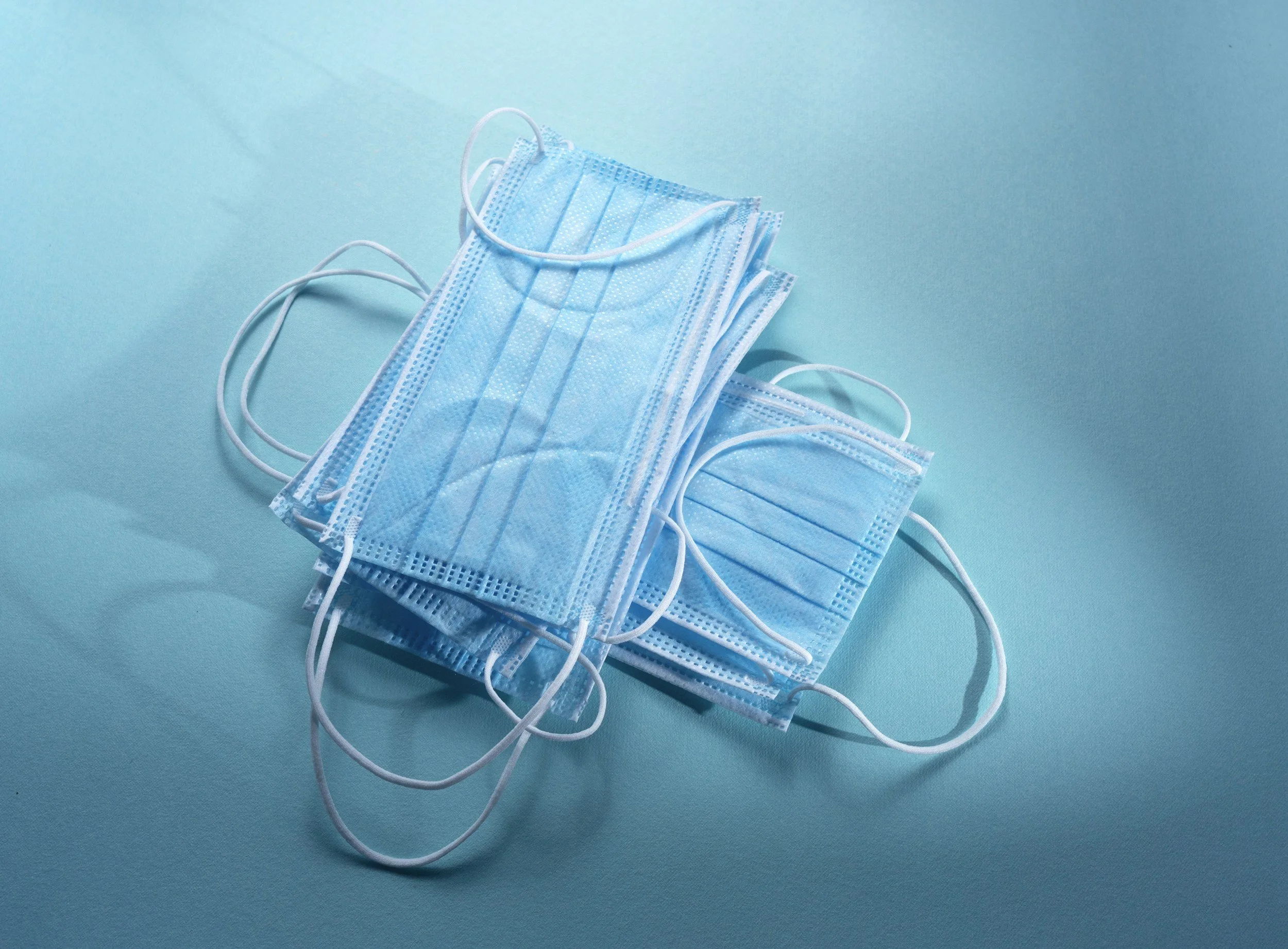 blue surgical masks against a blue background