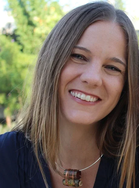 headshot of a woman with brown hair wearing a necklace