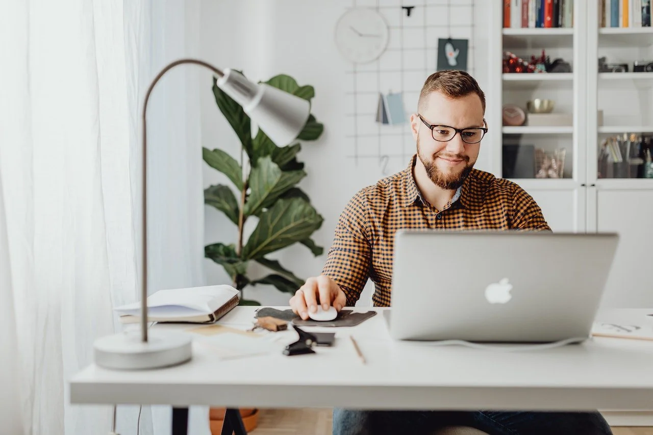 man sitting at a desk on a laptop