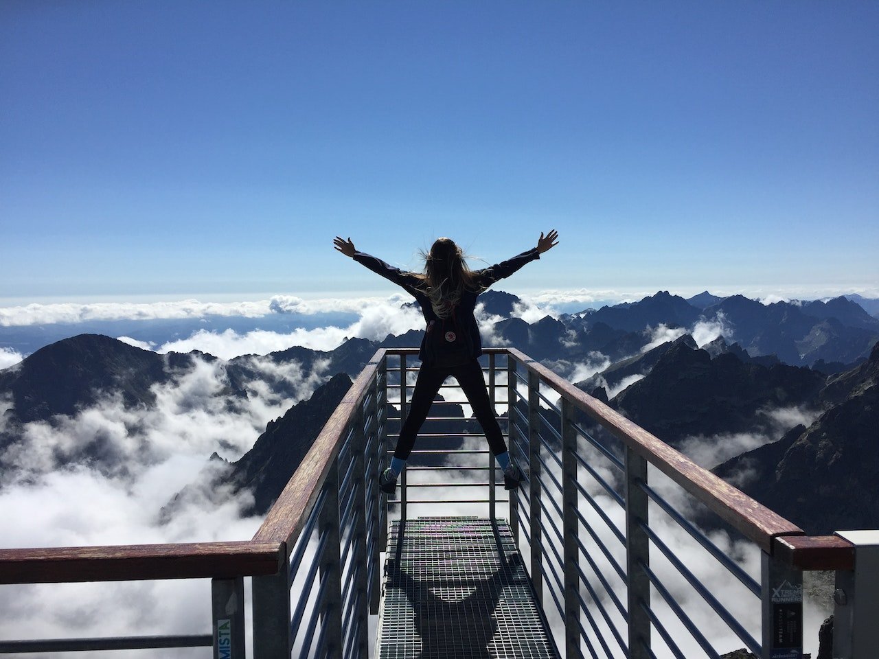 Person facing mountains with arms wide open