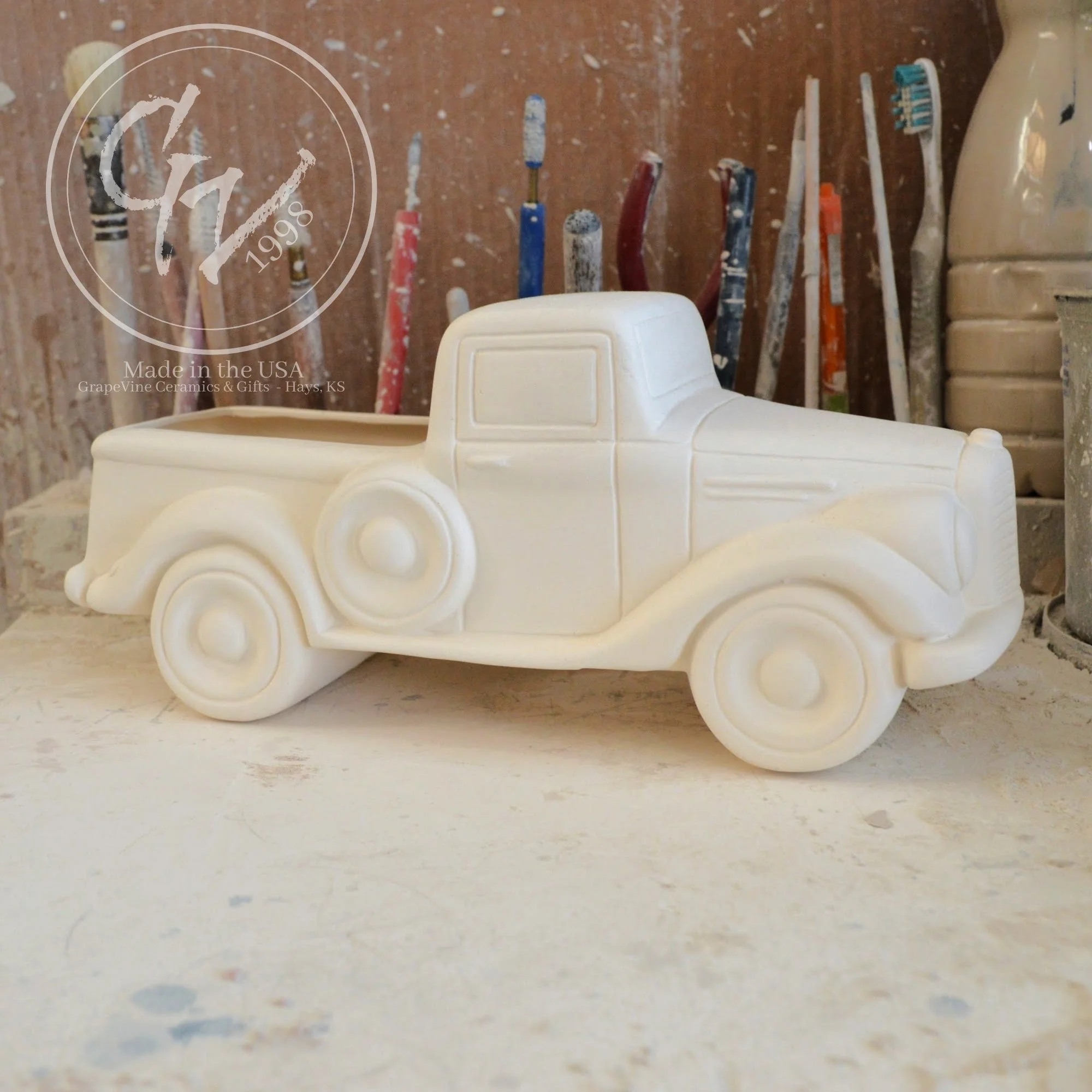 Close-up of the smooth, hand-cleaned surface of the unpainted ceramic truck showing wheel and door details.