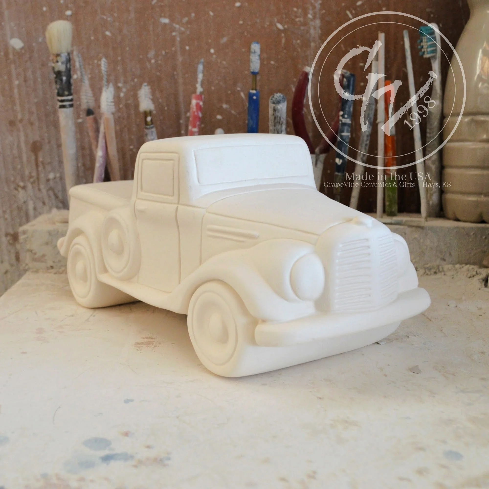 Close-up of the smooth, hand-cleaned surface of the unpainted ceramic truck showing wheel and door details.