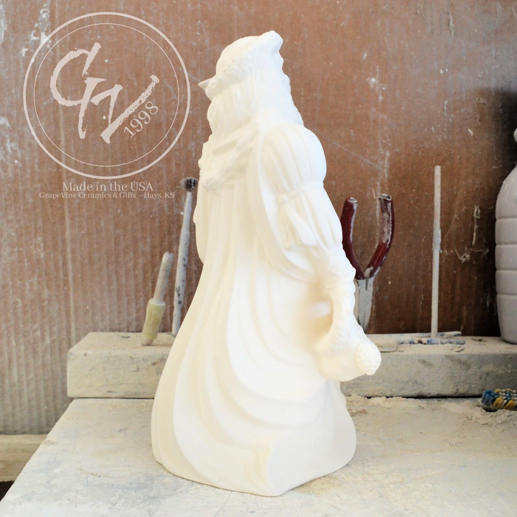 Side view of the Old English Santa bisque showing the flowing textures of the traditional hooded cloak.