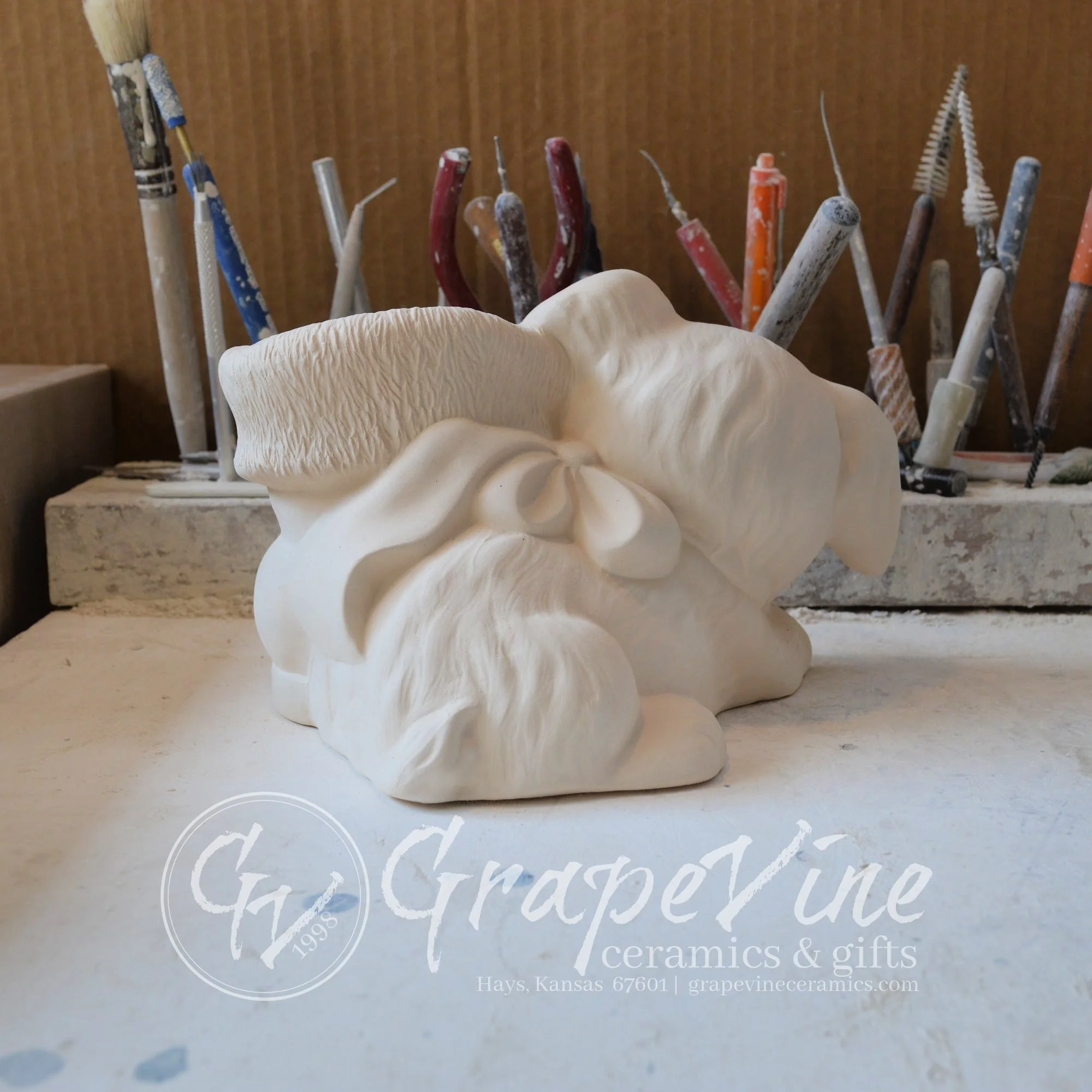 Back view of unpainted ceramic Puppy with Santa Boot figurine