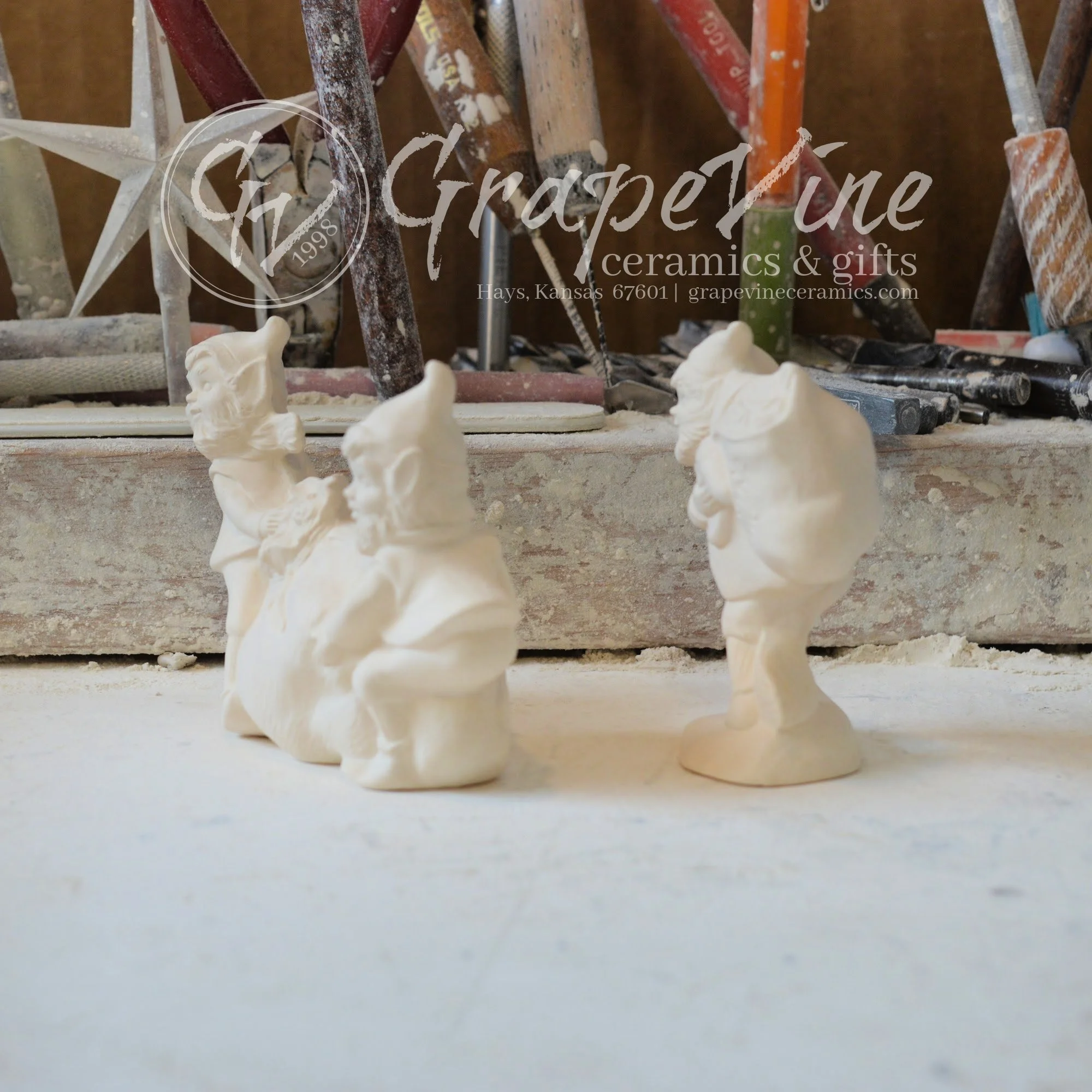 Side view of ceramic elf figurines with toy bag