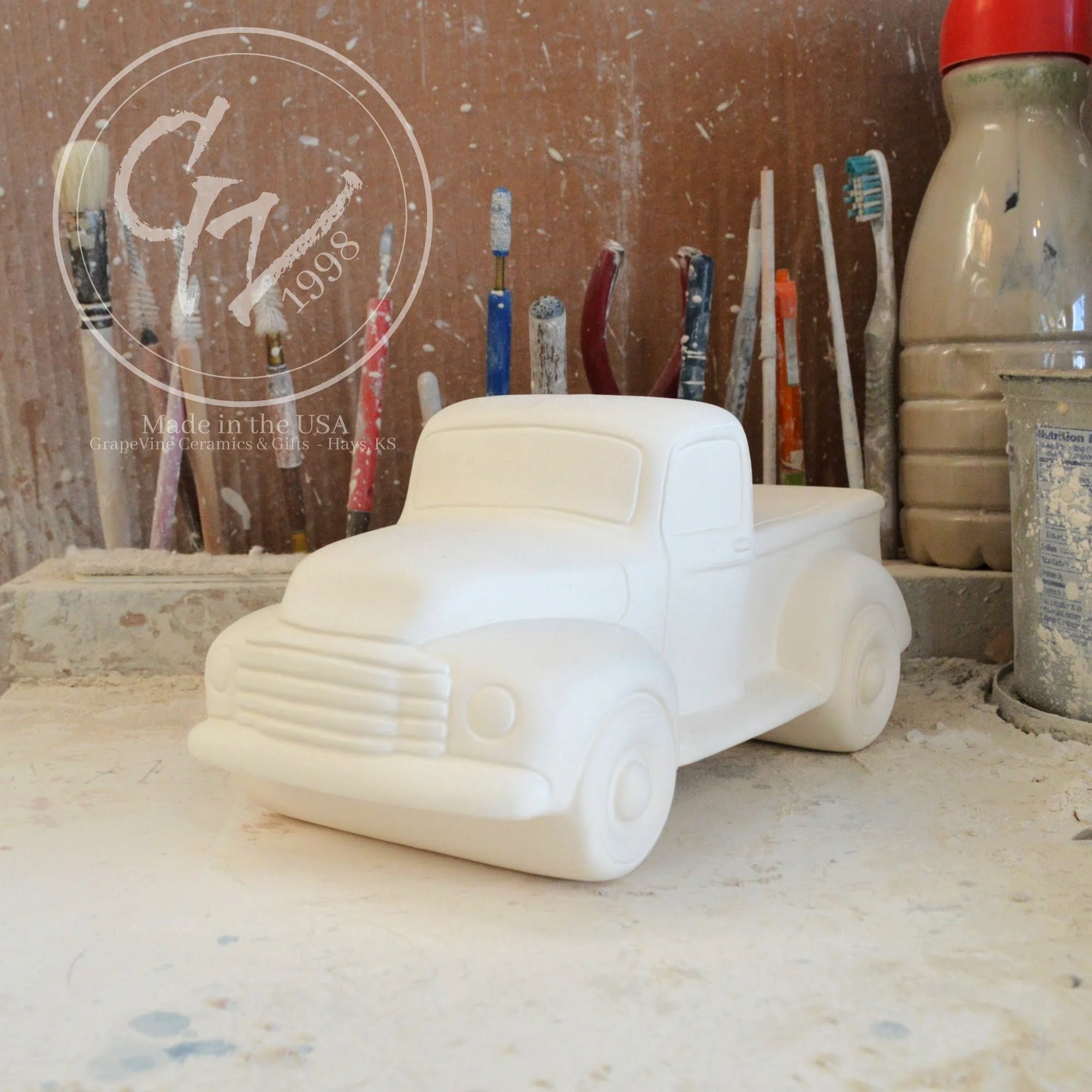 Unpainted white ceramic pickup truck bisque, front angle view, ready for DIY painting.
