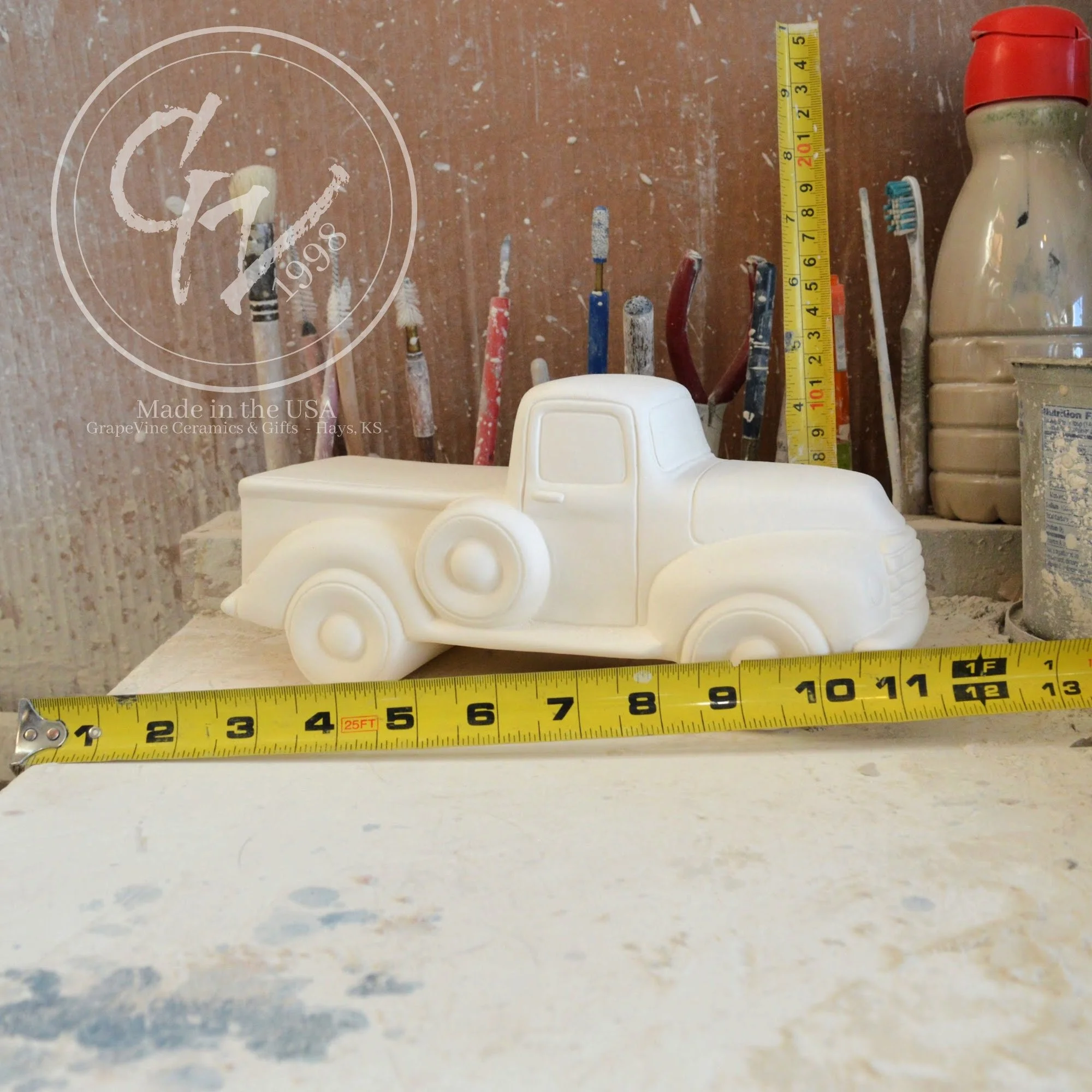 Unpainted white ceramic pickup truck bisque with tape measures, side view, ready for DIY painting.